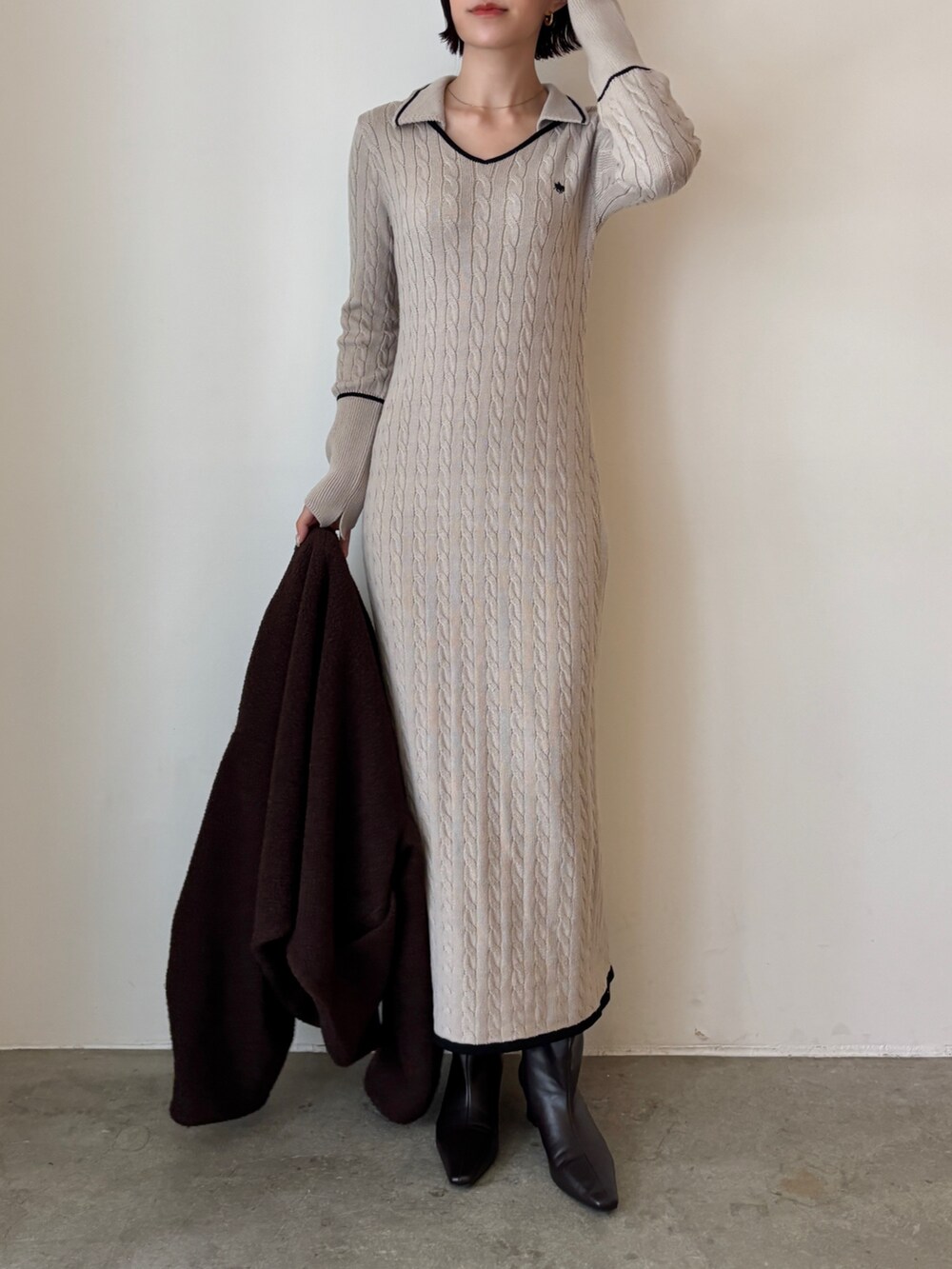 ベージュ系のワンピース、ブラウン系のブルゾン、ブラウン系のブーツを着用したレディースの秋コーディネートの2枚目の写真