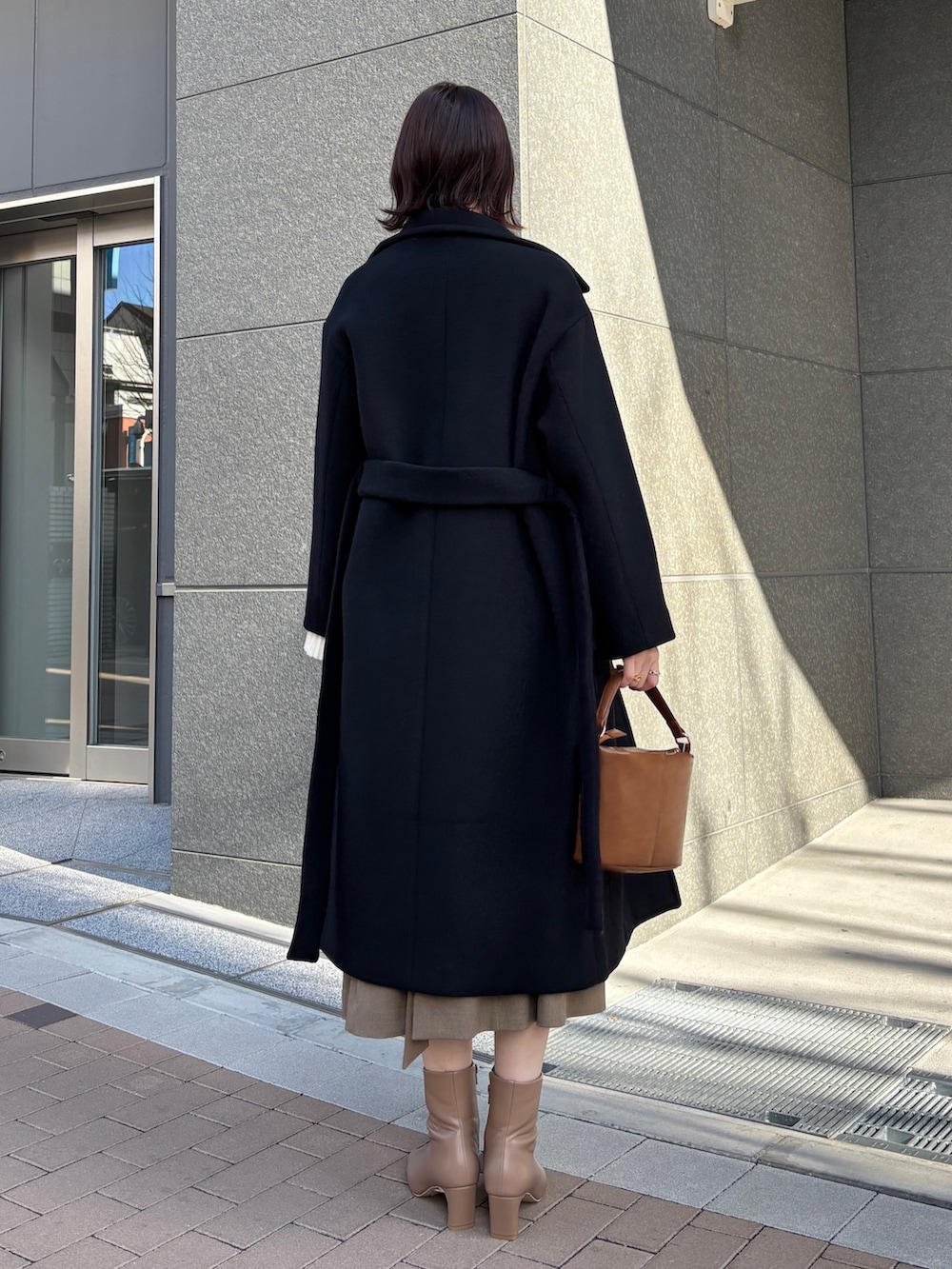 ブラウン系のワンピース、ホワイト系のニット/セーター、イエロー系のハンドバッグを着用したレディースの冬コーディネートの9枚目の写真