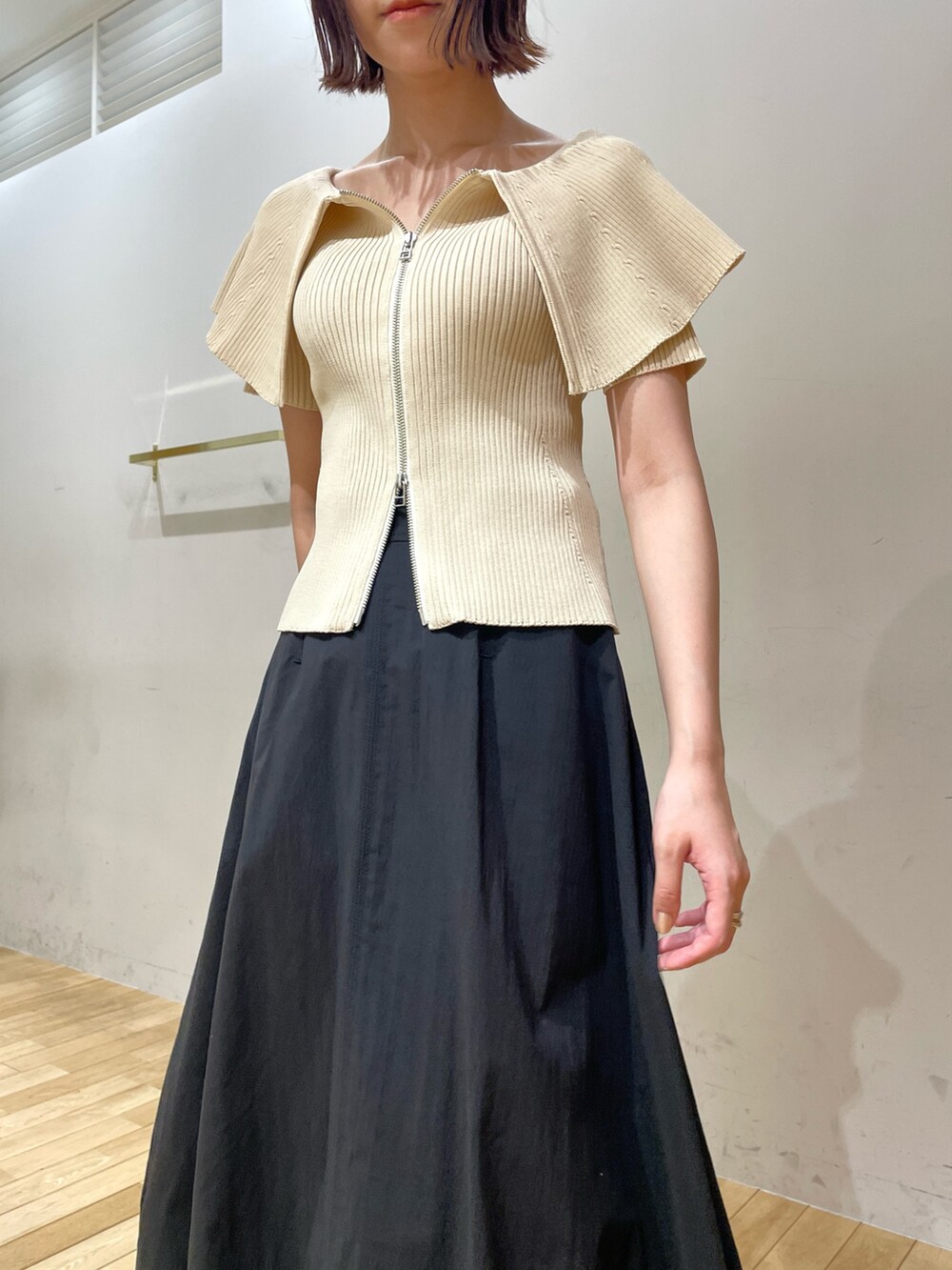 ブラック系のサンダル、ホワイト系のニット/セーター、ブラック系のスカートを着用したレディースの夏コーディネートの7枚目の写真