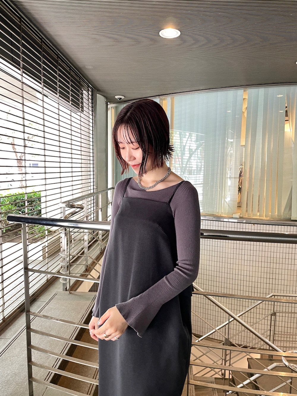 グレー系のニット/セーター、シルバー系のブーツ、ブラック系のワンピースを着用したレディースの秋コーディネートの5枚目の写真