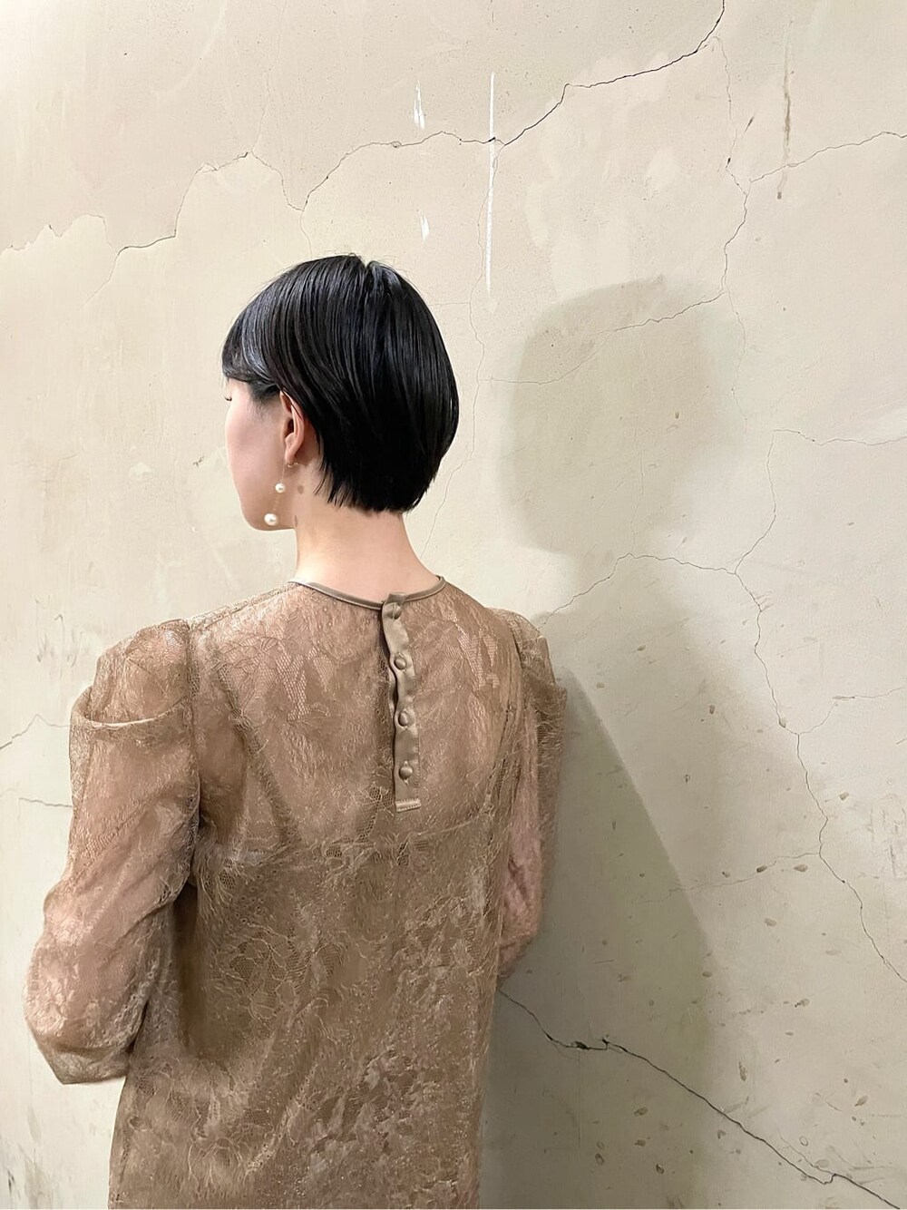 ゴールド系のパンプス、ベージュ系のドレス、ゴールド系のハンドバッグを着用したレディースの秋コーディネートの9枚目の写真