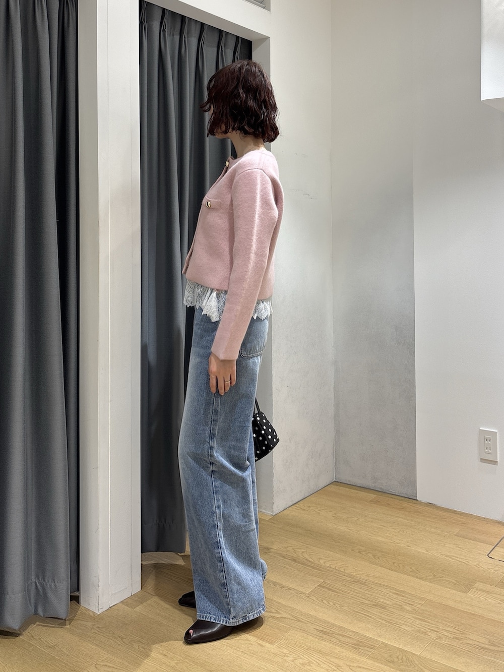 ブルー系のデニムパンツ、ピンク系のキャミソール、ピンク系のノーカラージャケットを着用したレディースの秋コーディネートの3枚目の写真