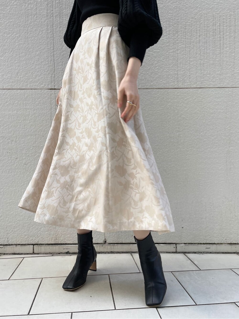 ブラック系のその他シューズ、ベージュ系のスカート、ブラック系のニット/セーターを着用したレディースの冬コーディネートの2枚目の写真