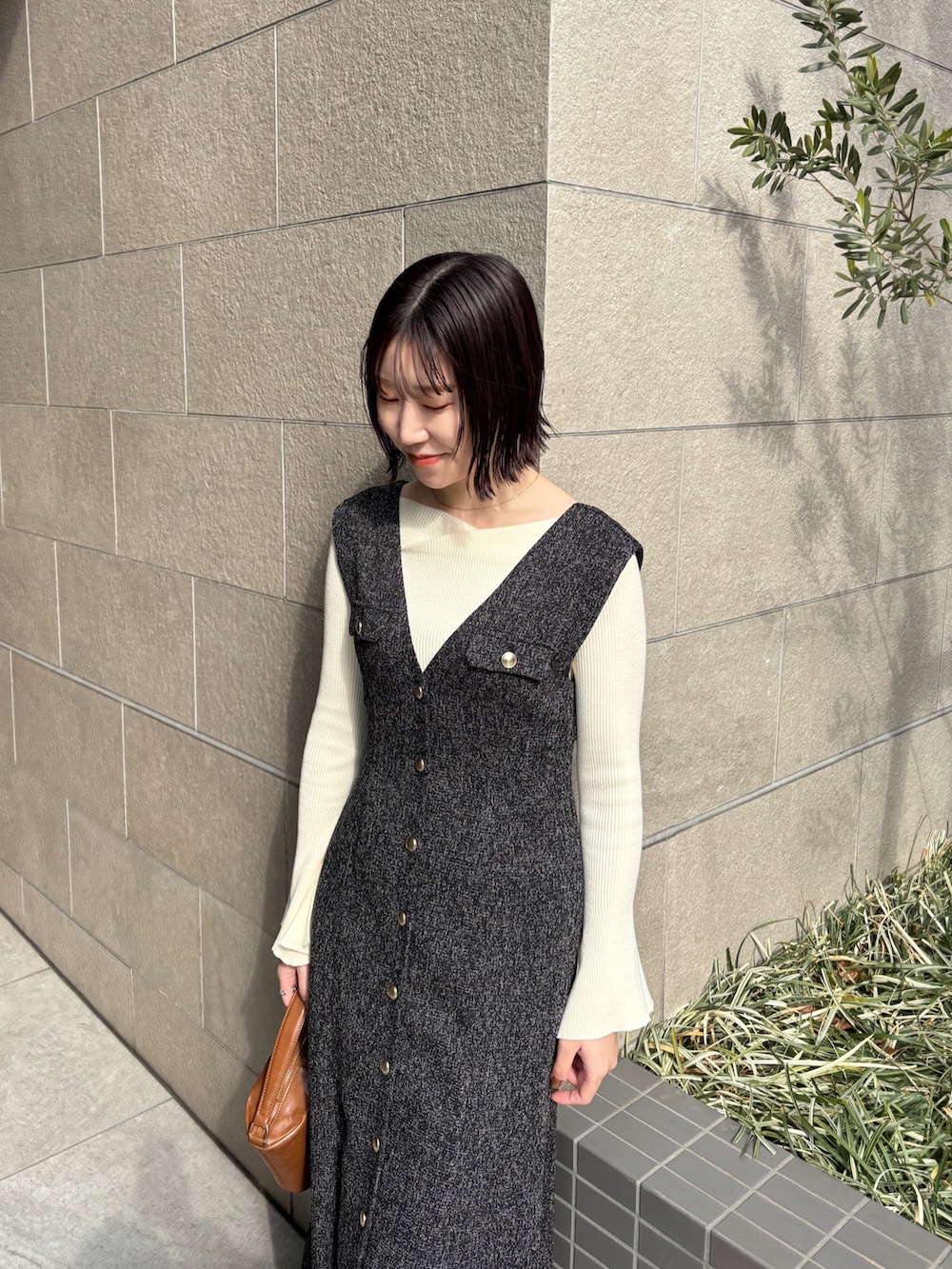 ブラック系のワンピース、ホワイト系のニット/セーター、イエロー系のハンドバッグを着用したレディースの冬コーディネートの4枚目の写真