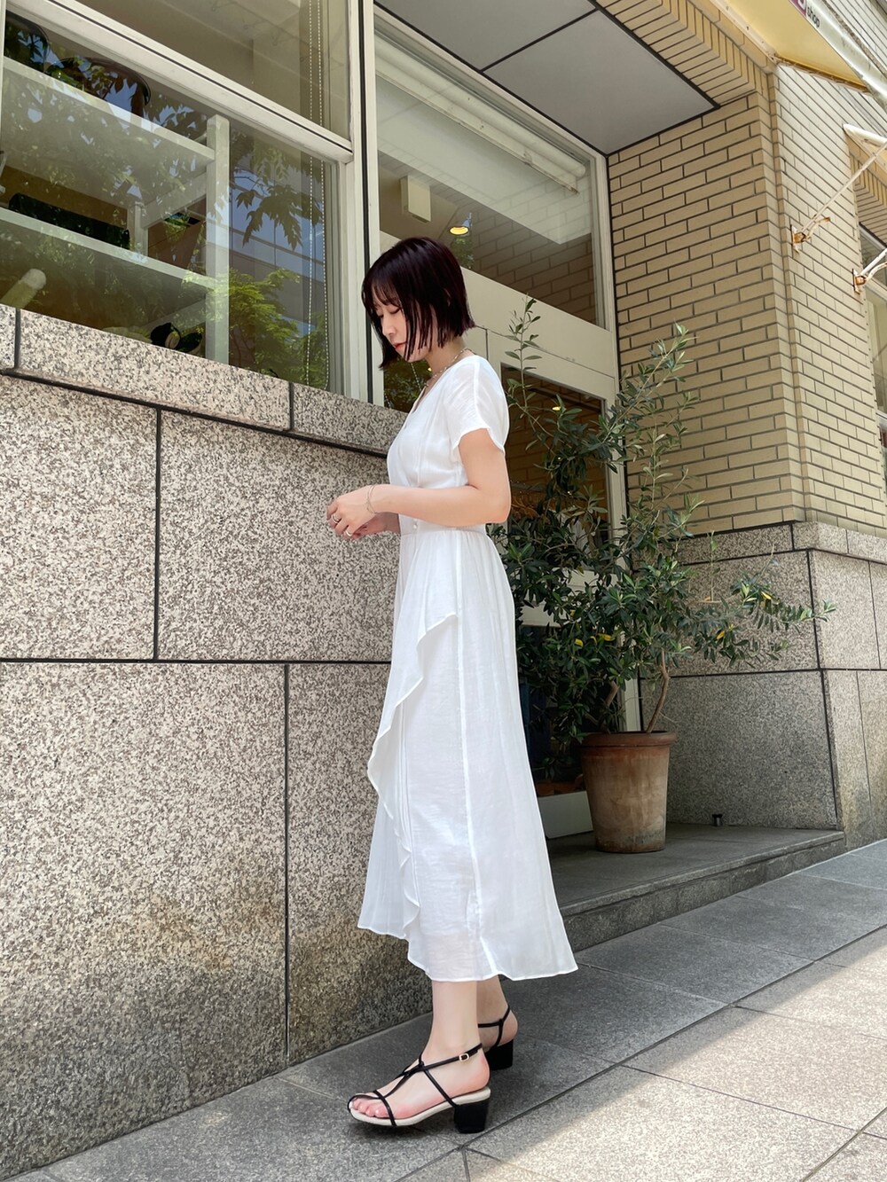 ブラウン系のショルダーバッグ、ホワイト系のワンピース、シルバー系のチョーカーを着用したレディースの夏コーディネートの3枚目の写真