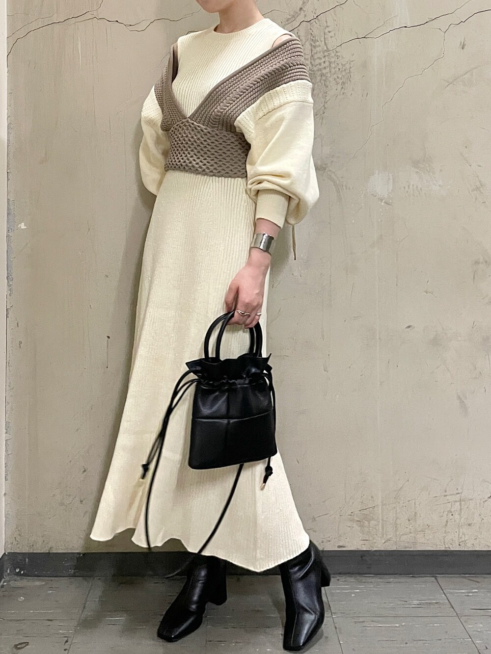 ホワイト系のワンピース、ブラック系のブーツ、ブラック系のハンドバッグを着用したレディースの秋コーディネートの3枚目の写真