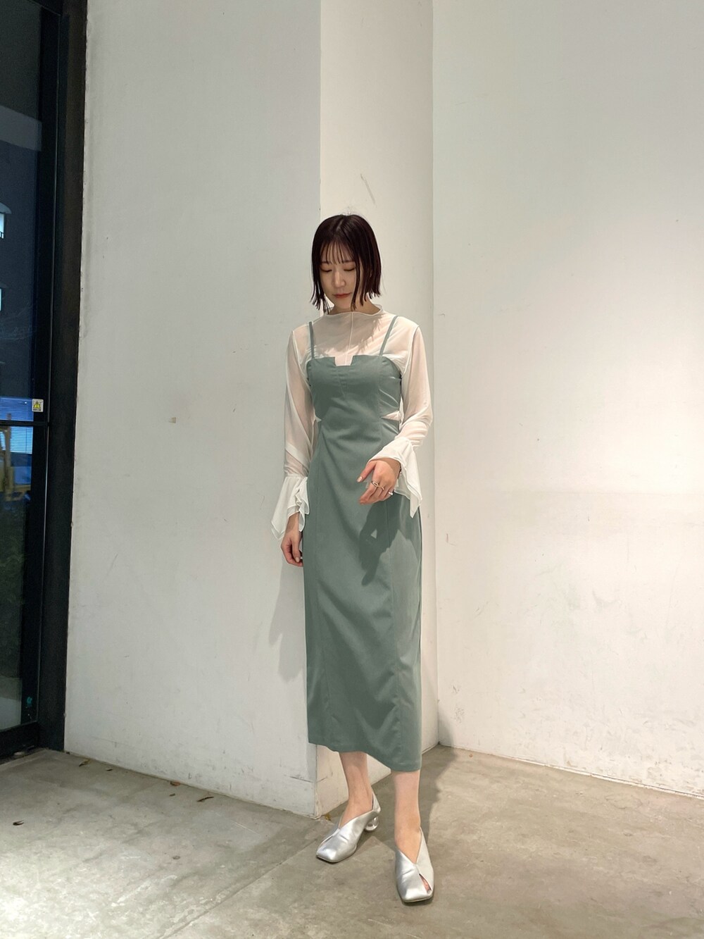 シルバー系のパンプス、グリーン系のワンピースを着用したレディースの春コーディネートの2枚目の写真