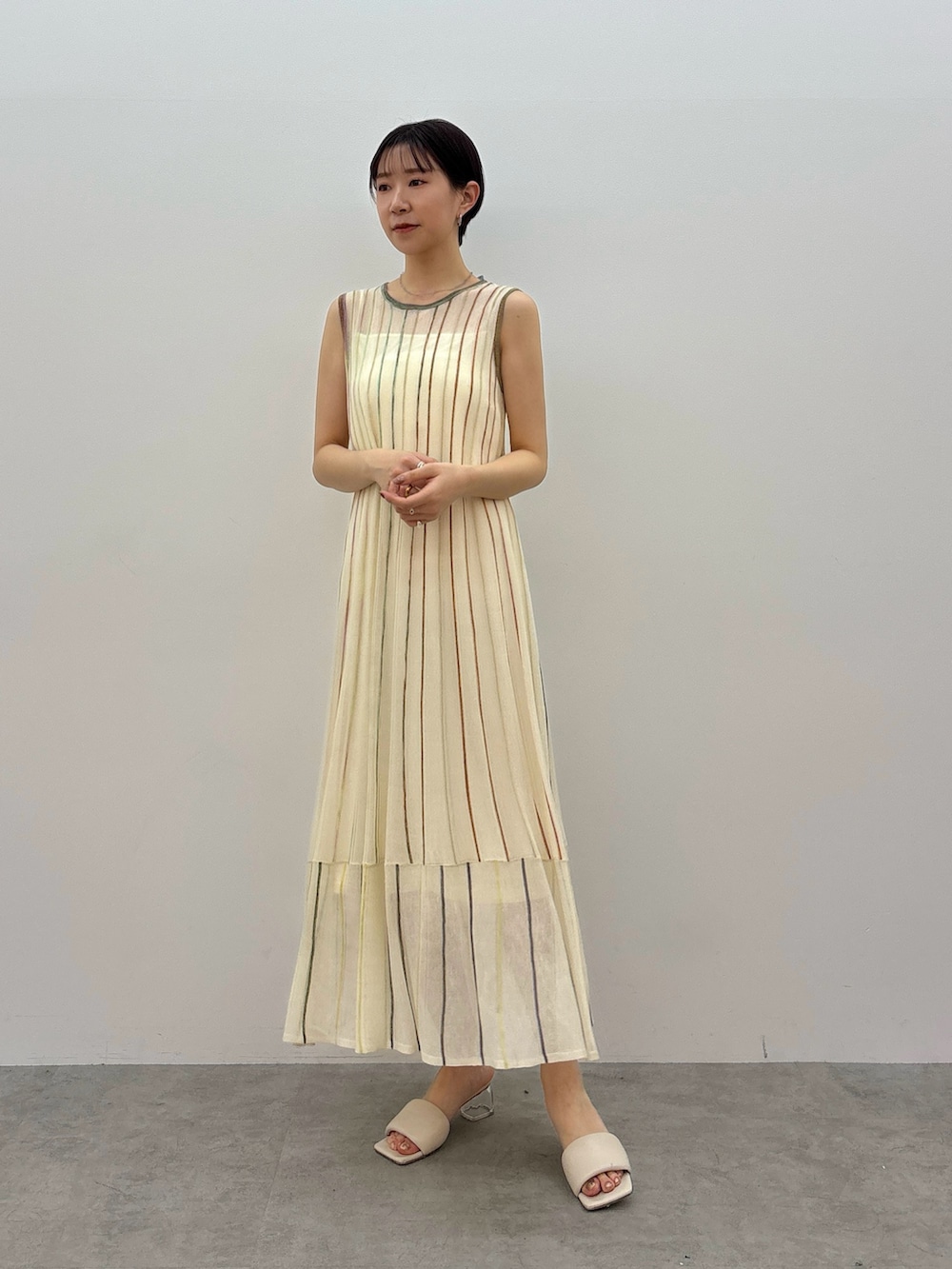 ホワイト系のワンピース、ホワイト系のサンダル、シルバー系のネックレスを着用したレディースの春コーディネートの2枚目の写真