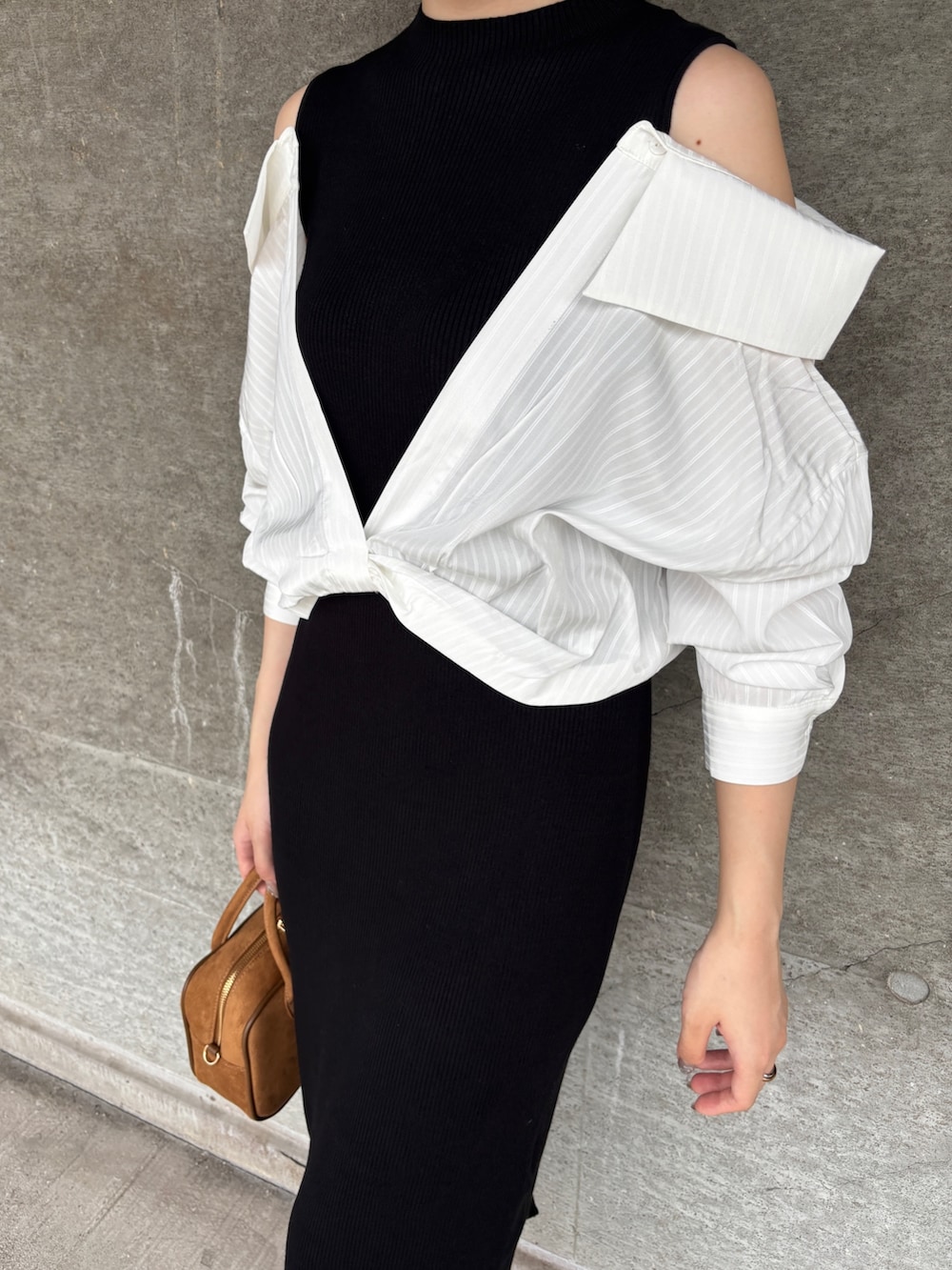 ブラック系のブーツ、イエロー系のハンドバッグ、ブラック系のワンピースを着用したレディースの秋コーディネートの5枚目の写真