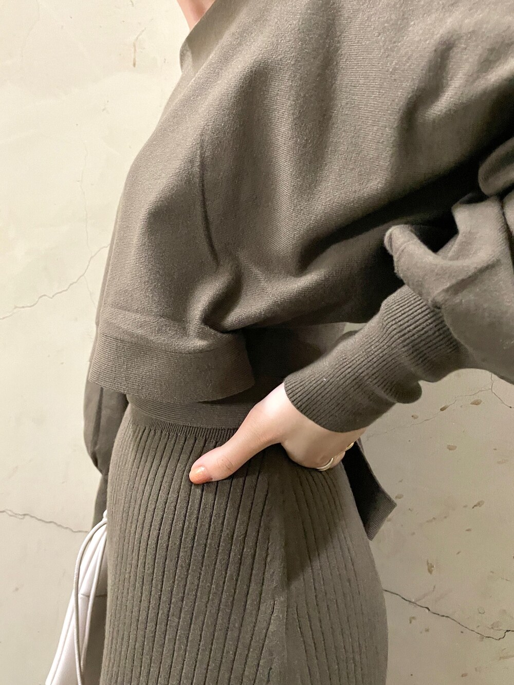 ブラウン系のワンピース、ブラック系のブーツ、ホワイト系のハンドバッグを着用したレディースの秋コーディネートの7枚目の写真