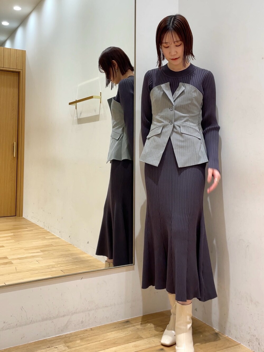 ホワイト系のブーツ、グレー系のワンピースを着用したレディースの冬コーディネートの3枚目の写真