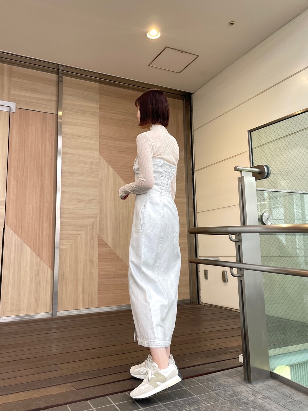 ホワイト系のショルダーバッグ、ホワイト系のワンピース、ブラック系のデニムジャケットを着用したレディースの春コーディネートの3枚目の写真