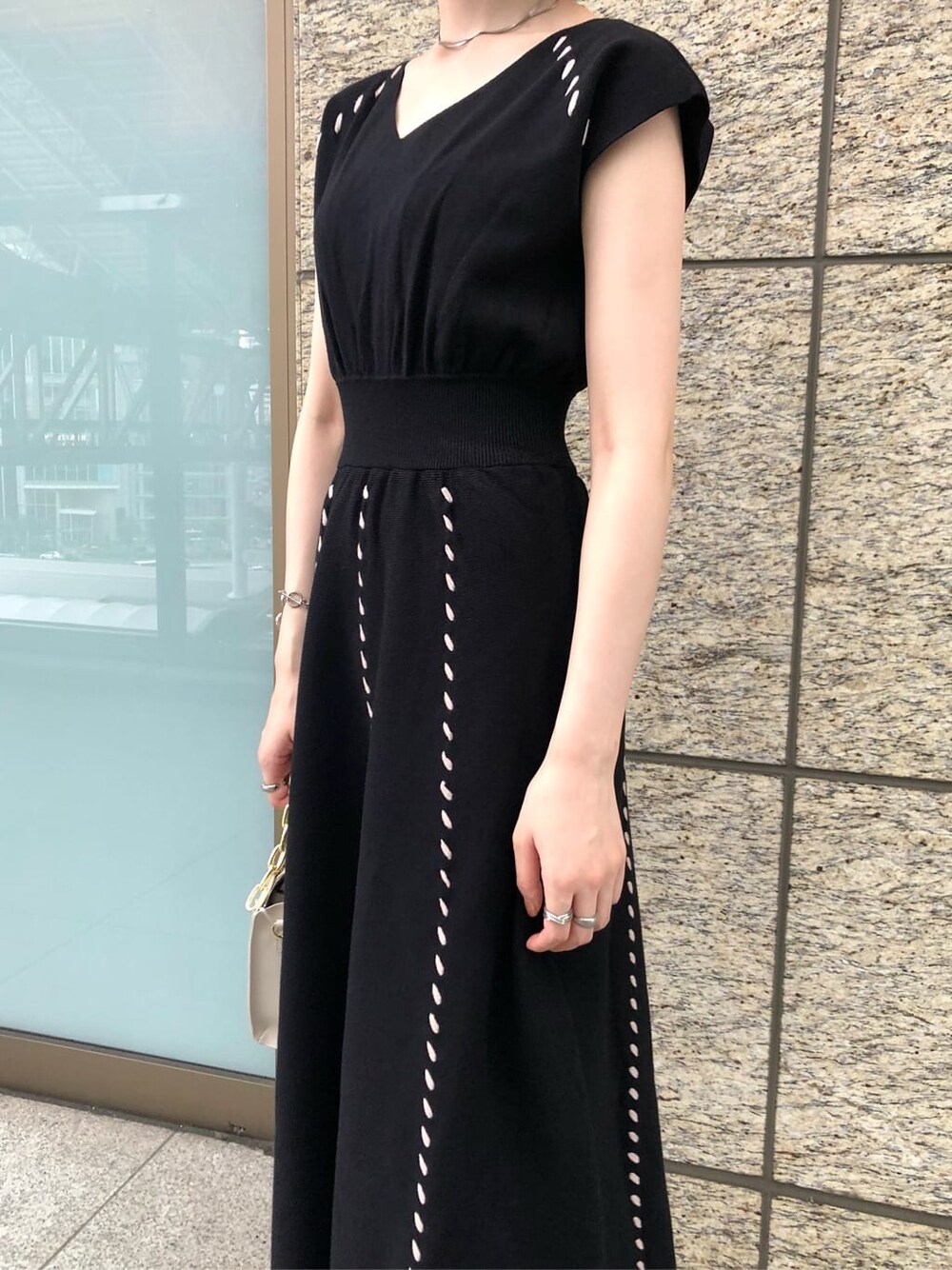 ブラック系のワンピース、ベージュ系のパンプス、ホワイト系のショルダーバッグを着用したレディースの夏コーディネートの3枚目の写真