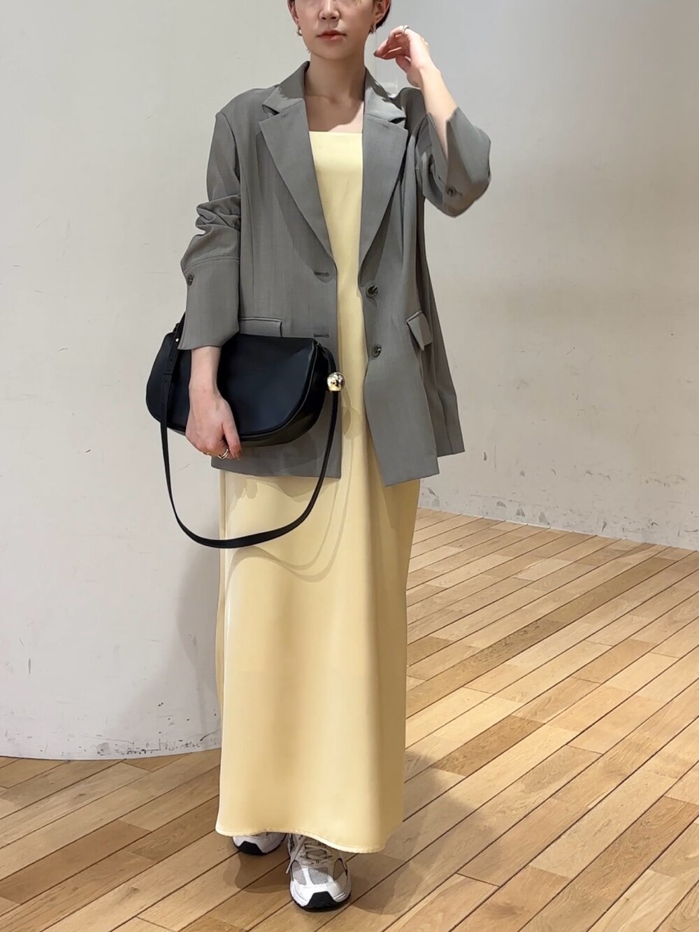 ホワイト系のワンピース、ホワイト系のテーラードジャケット、ブラック系のショルダーバッグを着用したレディースの春コーディネートの3枚目の写真