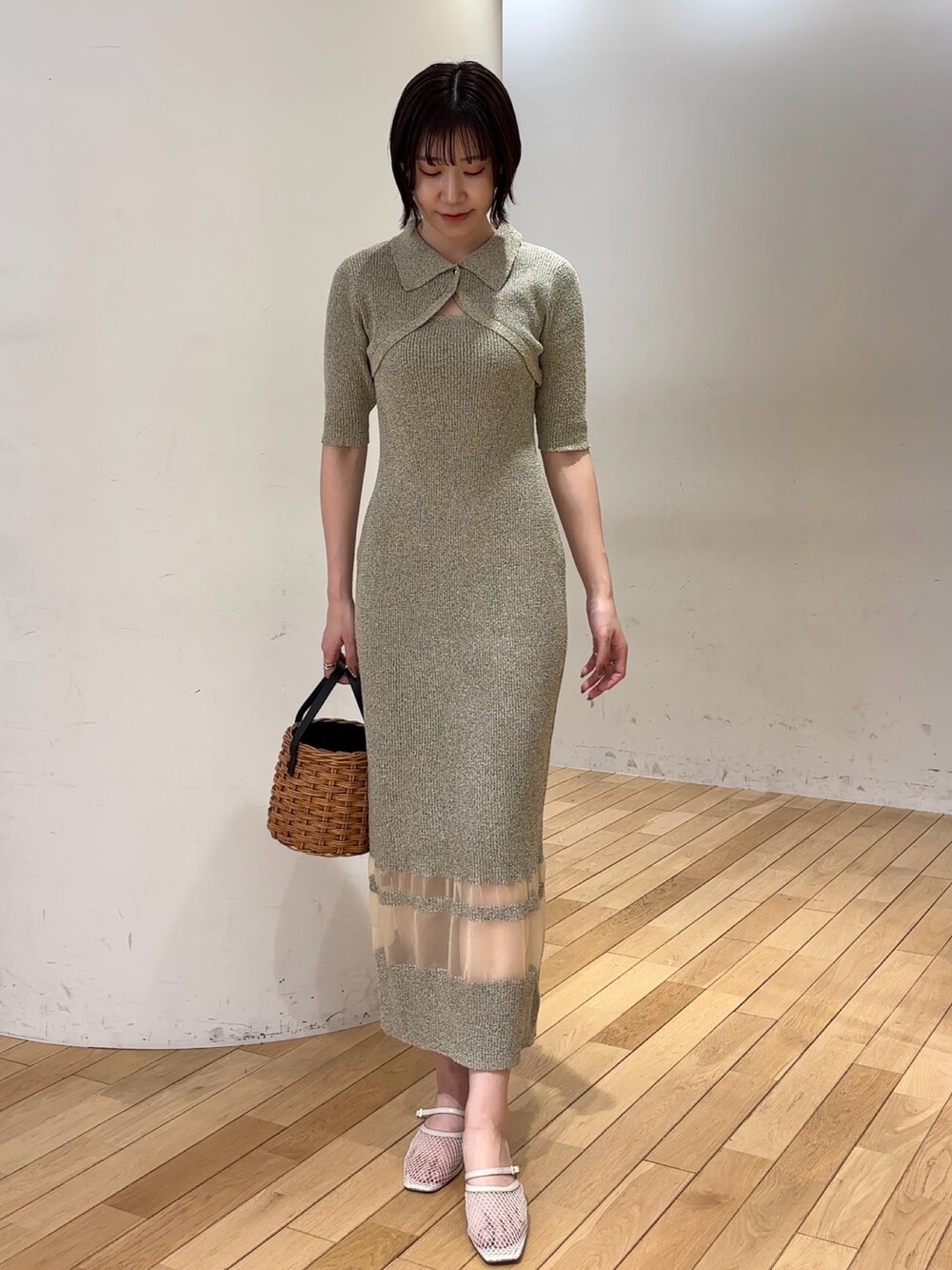 ベージュ系のワンピース、ブラウン系のハンドバッグ、ホワイト系のサンダルを着用したレディースの春コーディネートの2枚目の写真