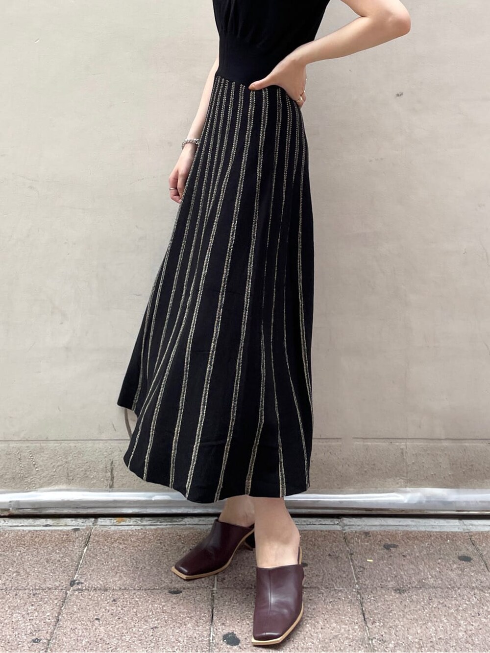 レッド系のサンダル、ブラック系のワンピースを着用したレディースの夏コーディネートの7枚目の写真