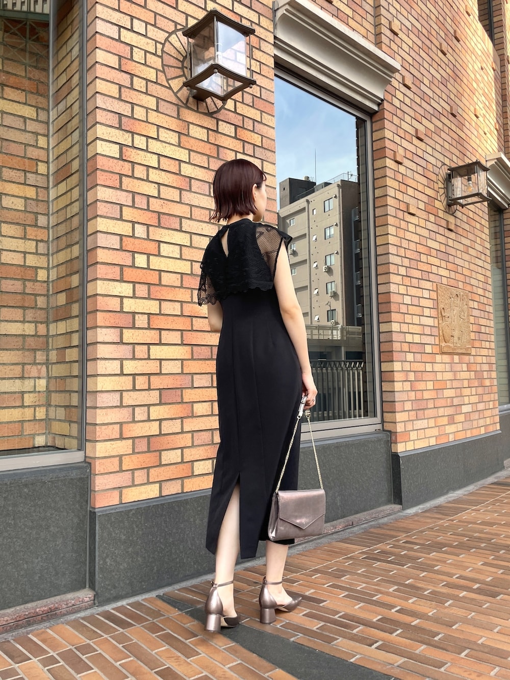 ブラック系のドレス、シルバー系のハンドバッグ、その他のパンプスを着用したレディースの秋コーディネートの3枚目の写真