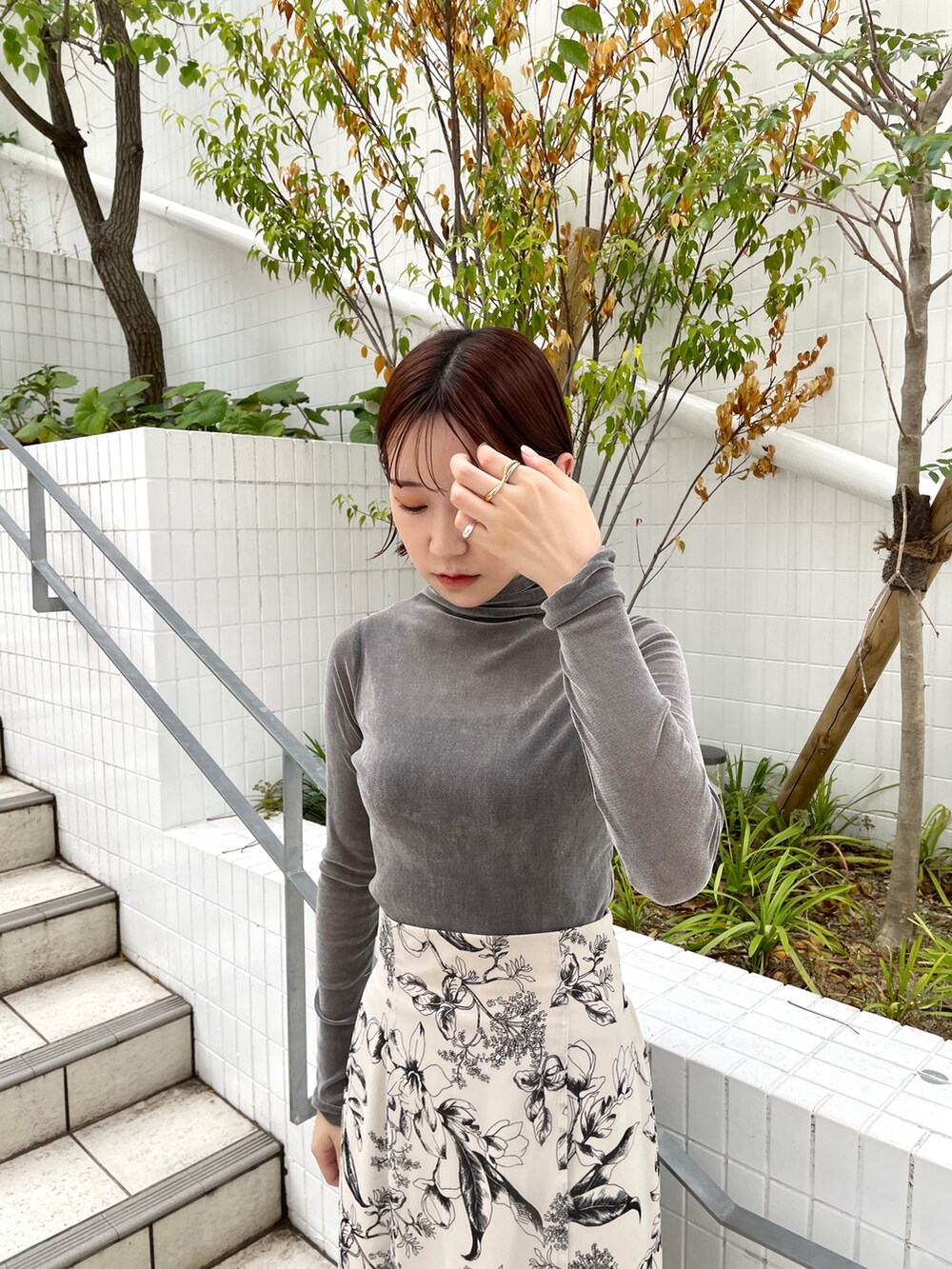 グレー系のTシャツ/カットソー、ホワイト系のスカート、ブラック系のブーツを着用したレディースの秋コーディネートの5枚目の写真