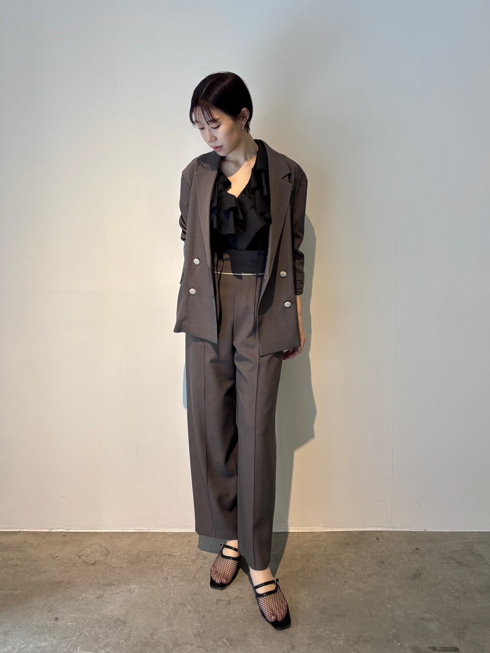 グレー系のスラックス、ブラック系のシャツ/ブラウス、ブラック系のサンダルを着用したレディースの春コーディネートの6枚目の写真