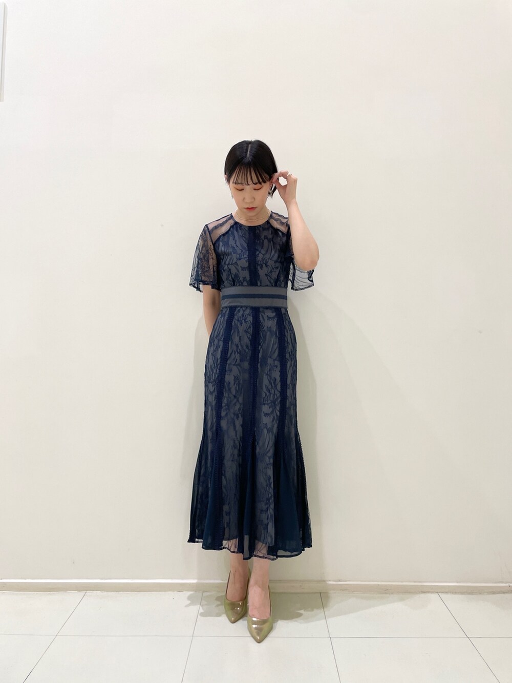 ブルー系のドレス、ゴールド系のパンプス、ホワイト系のネックレスを着用したレディースの春コーディネートの2枚目の写真