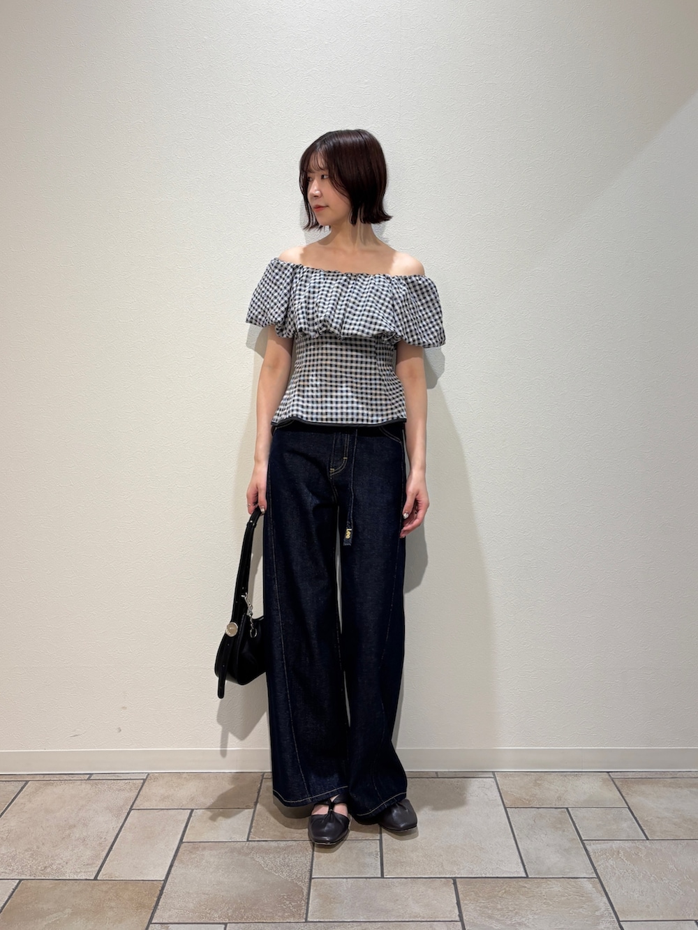 ブラック系のシャツ/ブラウス、ブルー系のデニムパンツ、ブラウン系のサンダルを着用したレディースの夏コーディネートの2枚目の写真