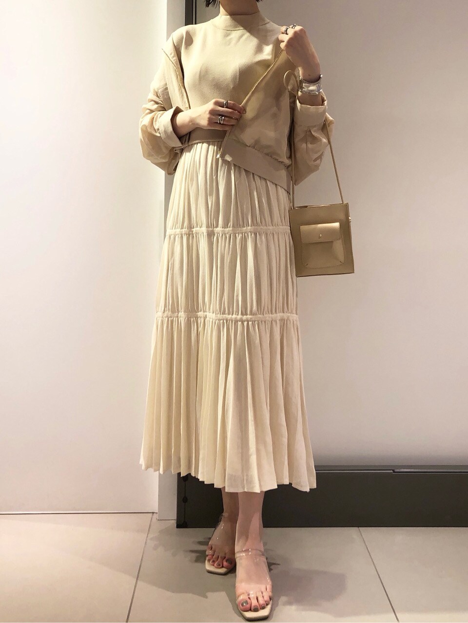 ベージュ系のハンドバッグ、ベージュ系のブルゾン、ベージュ系のワンピースを着用したレディースの春コーディネートの4枚目の写真