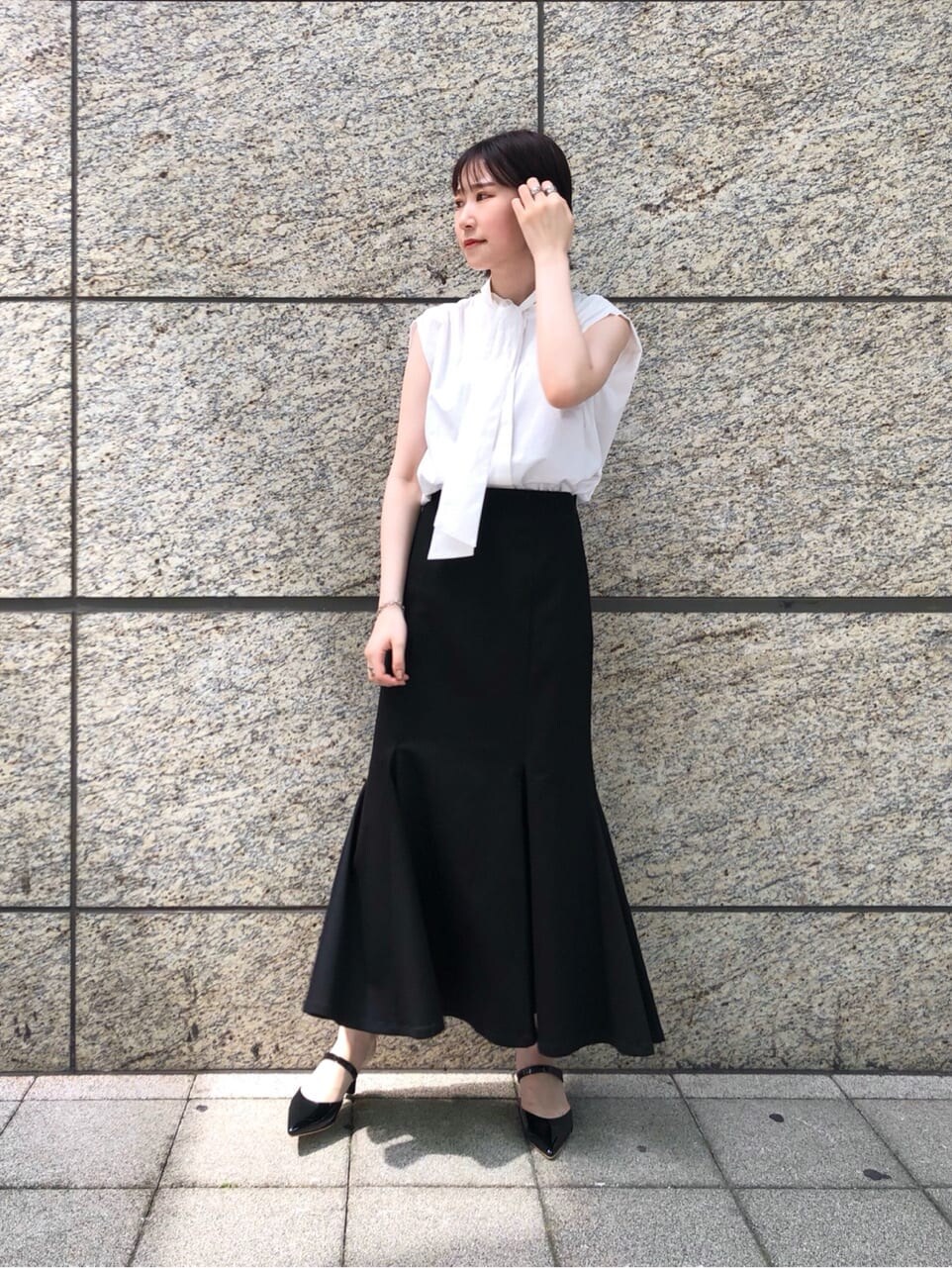 ブラック系のその他シューズ、ホワイト系のシャツ/ブラウス、ブラック系のスカートを着用したレディースの夏コーディネートの2枚目の写真