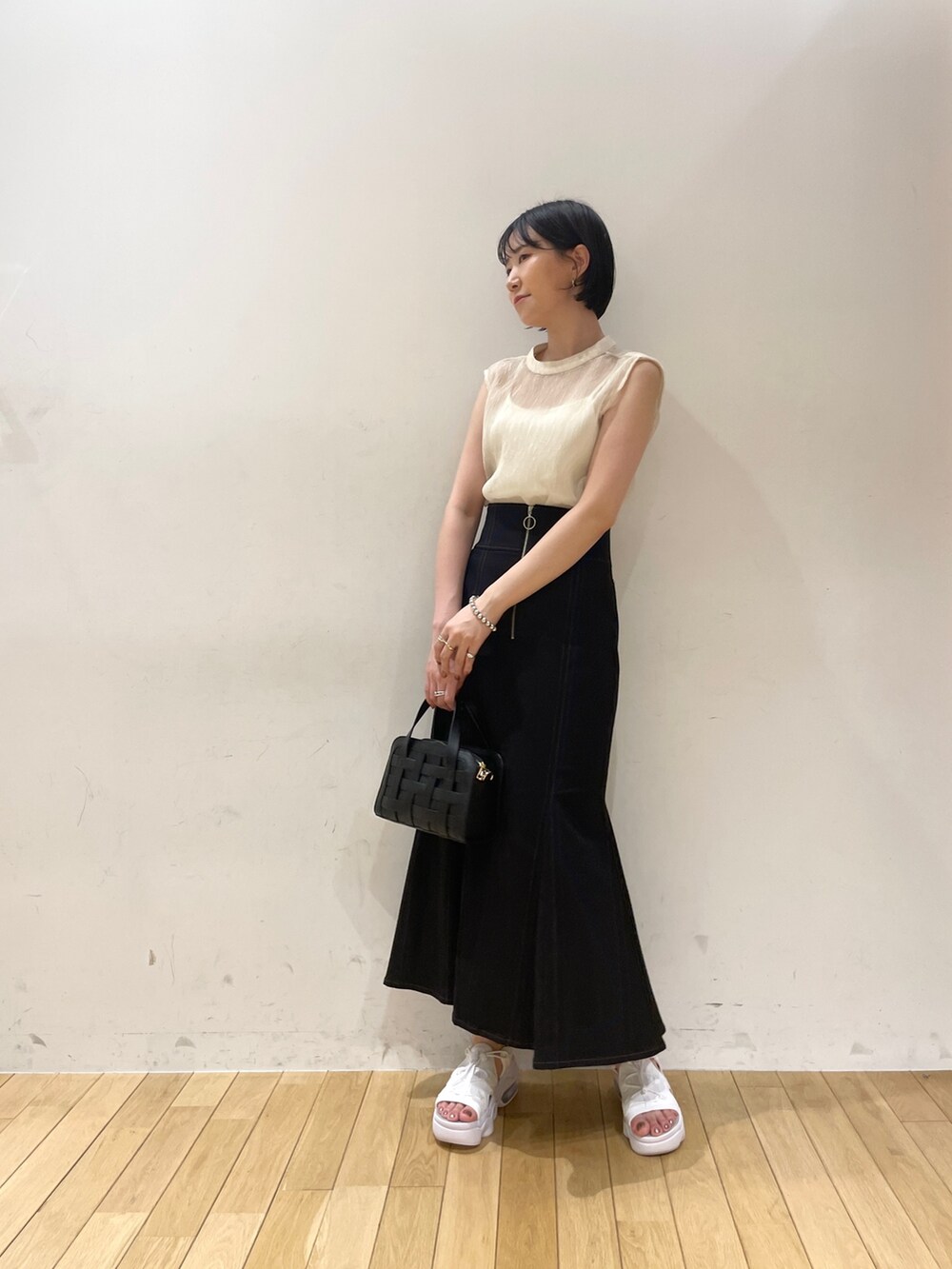 ホワイト系のシャツ/ブラウス、ブラック系のスカート、ブラック系のショルダーバッグを着用したレディースの夏コーディネートの3枚目の写真