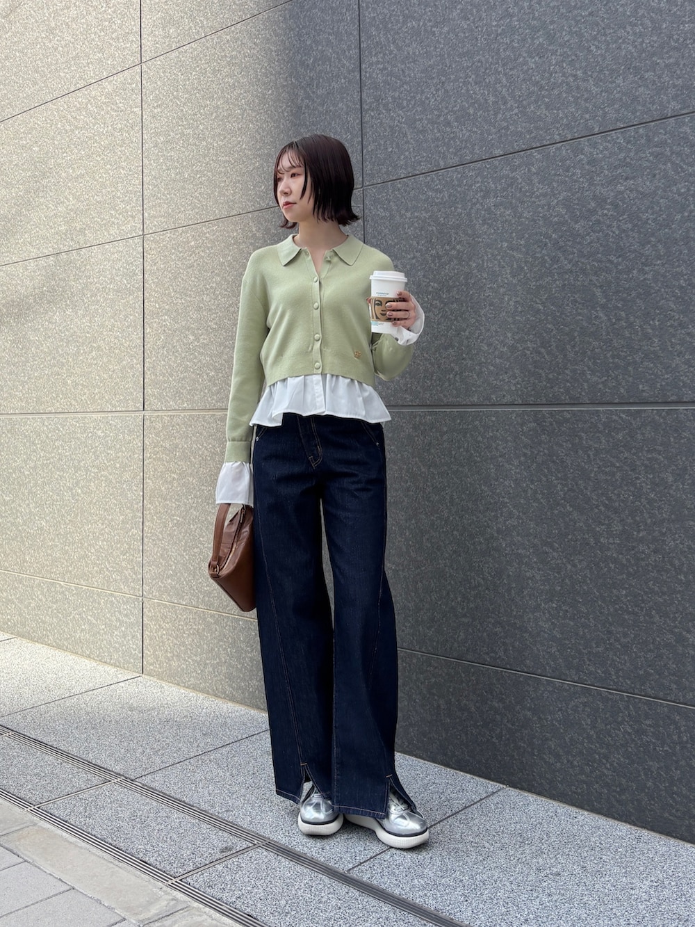 ホワイト系のブルゾン、ブルー系のデニムパンツ、イエロー系のハンドバッグを着用したレディースの冬コーディネートの5枚目の写真