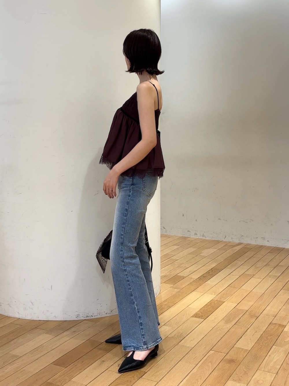 ブルー系のデニムパンツ、ブラック系のハンドバッグ、ブラック系のパンプスを着用したレディースの夏コーディネートの2枚目の写真