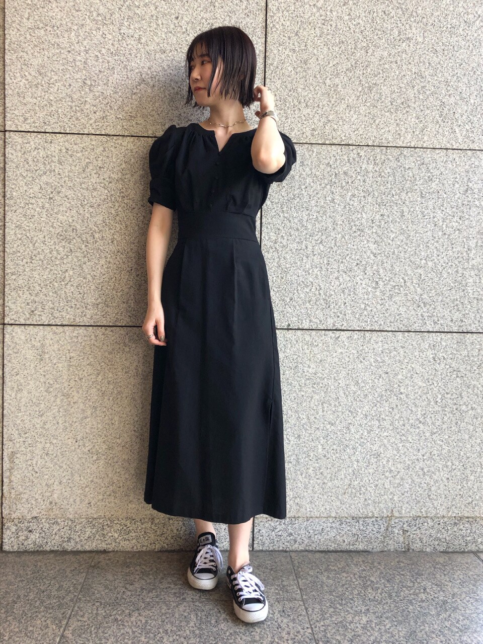 ブラック系のその他シューズ、グリーン系のハンドバッグ、ブラック系のワンピースを着用したレディースの春コーディネートの2枚目の写真