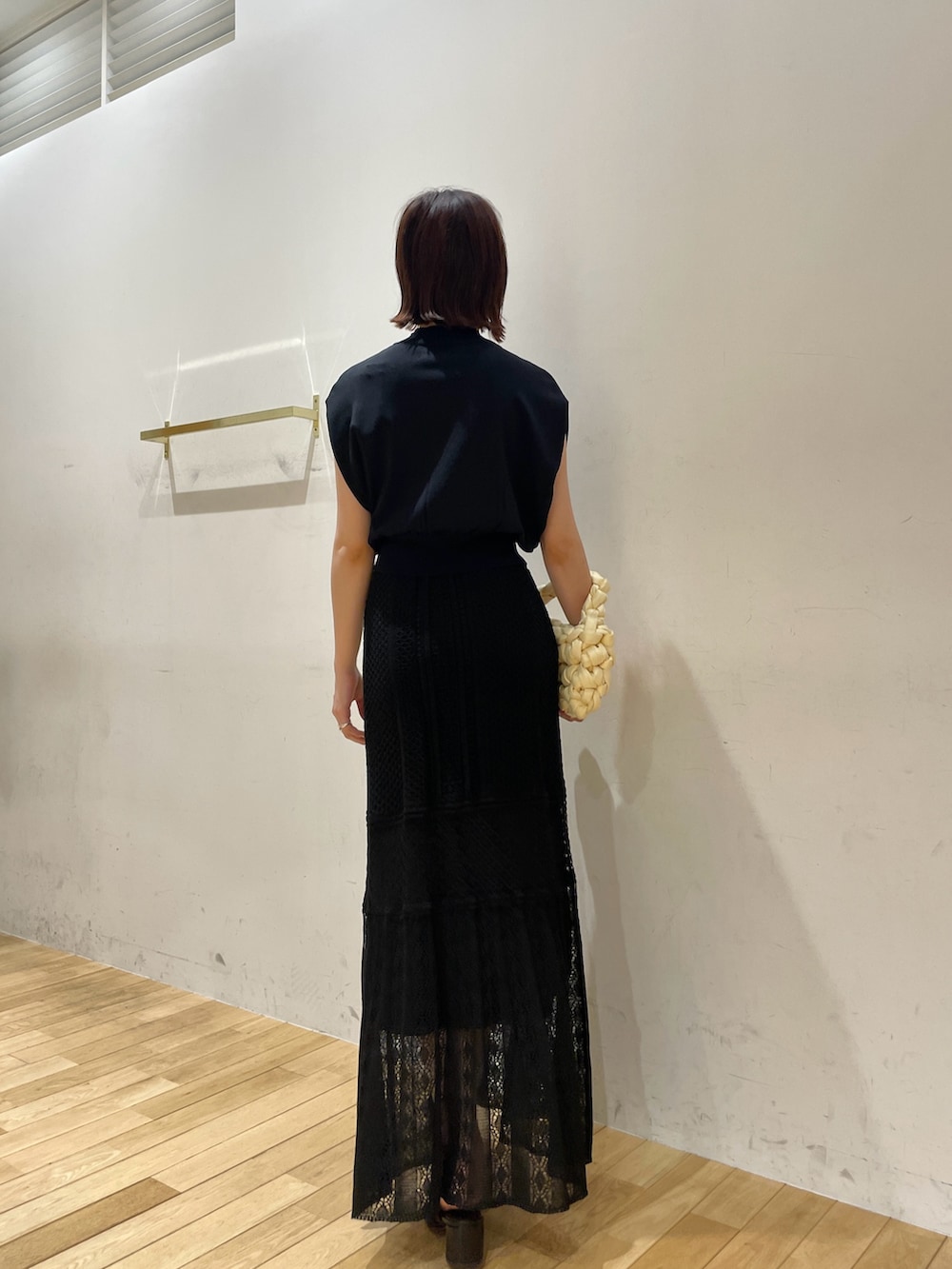 ベージュ系のハンドバッグ、ブラック系のサンダル、ブラック系のニット/セーターを着用したレディースの夏コーディネートの5枚目の写真