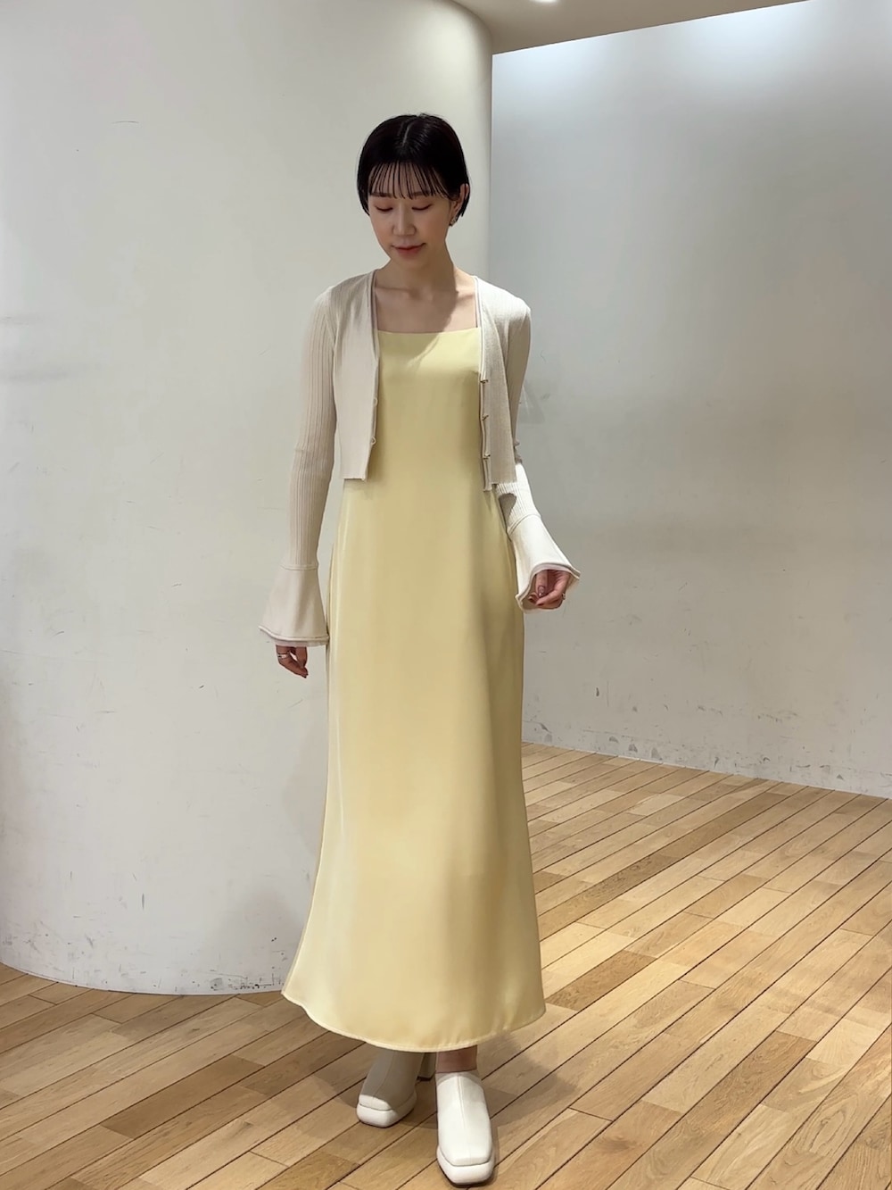 ホワイト系のワンピース、ホワイト系のサンダル、ブルー系のアンサンブルを着用したレディースの春コーディネートの2枚目の写真