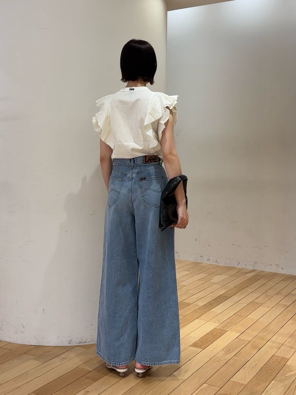 ホワイト系のシャツ/ブラウス、ブルー系のデニムパンツ、ホワイト系のサンダルを着用したレディースの夏コーディネートの4枚目の写真