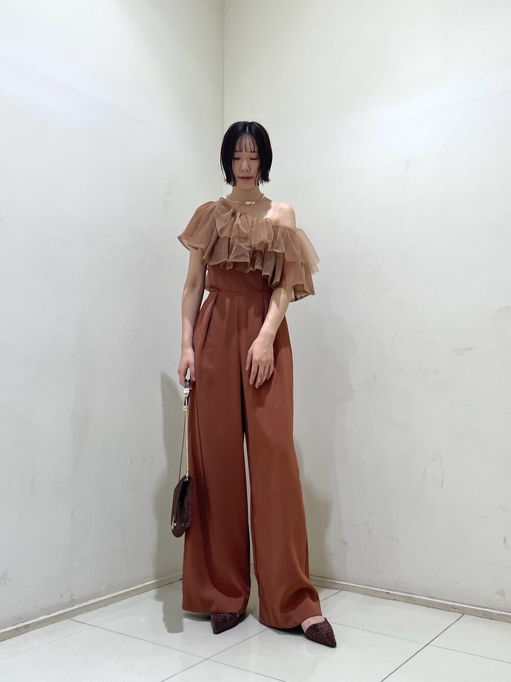 オレンジ系のパンツドレス、その他のクラッチバッグ、その他のパンプスを着用したレディースの夏コーディネートの4枚目の写真