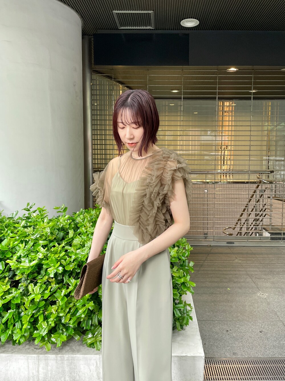 グリーン系のパンツドレス、ベージュ系のパンプスを着用したレディースの春コーディネートの6枚目の写真