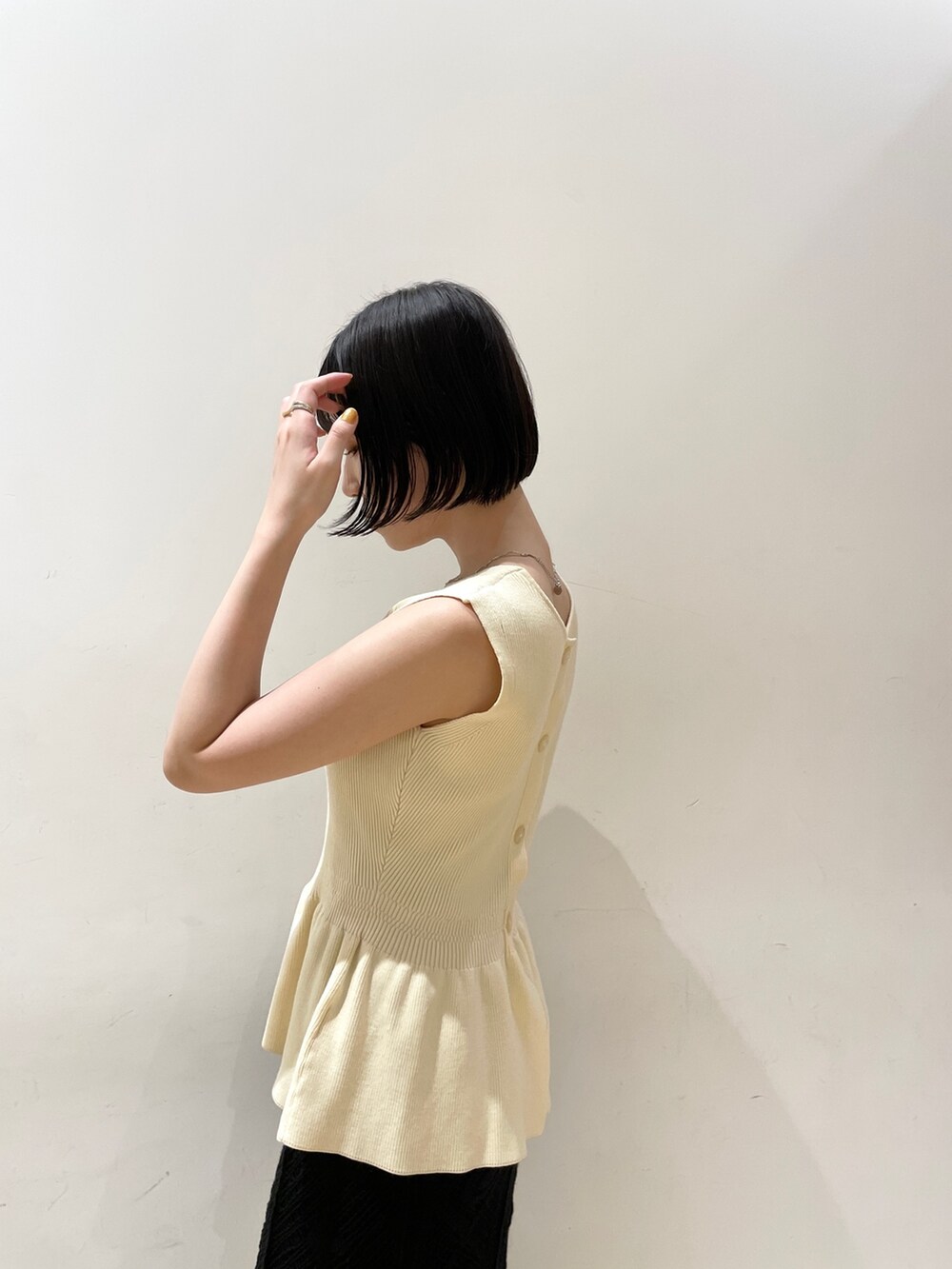 ベージュ系のハンドバッグ、ホワイト系のニット/セーター、ブラック系のスカートを着用したレディースの夏コーディネートの7枚目の写真