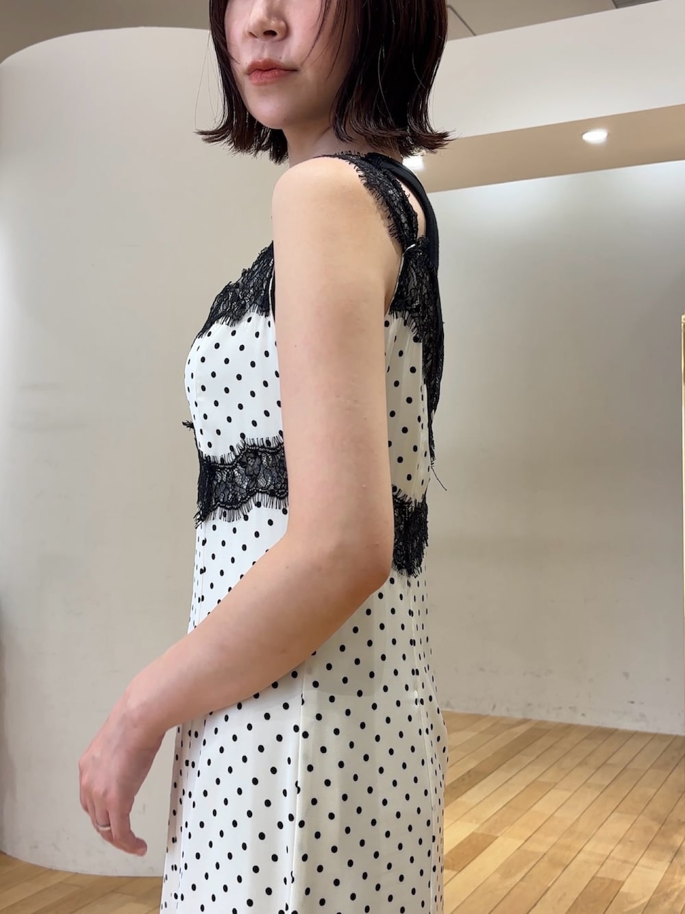 ホワイト系のワンピース、ブラック系のタンクトップ、ホワイト系のサンダルを着用したレディースの夏コーディネートの5枚目の写真