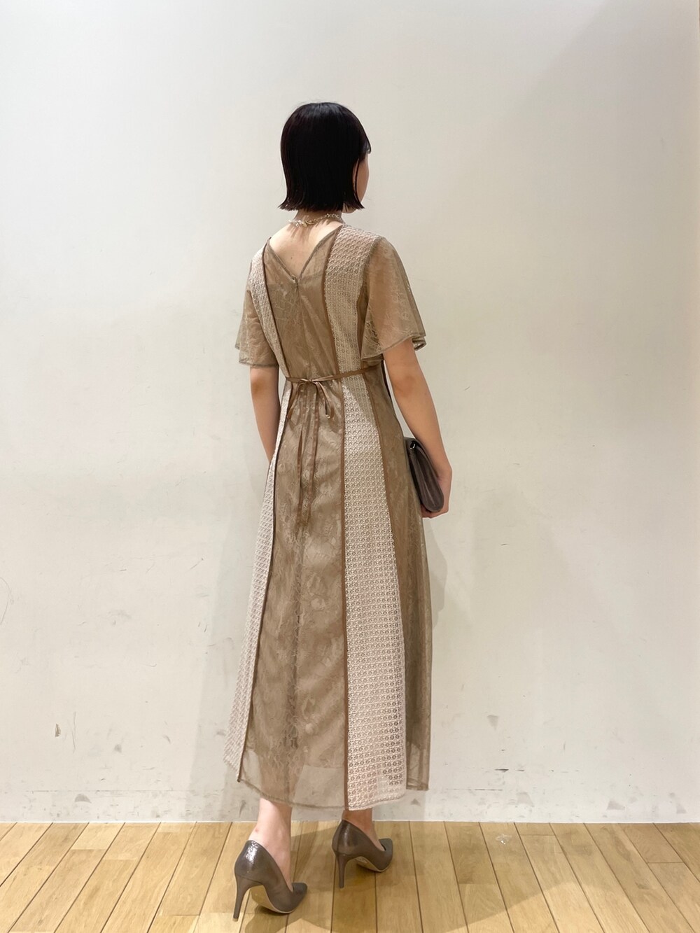 ブラウン系のドレス、シルバー系のハンドバッグ、シルバー系のパンプスを着用したレディースの秋コーディネートの3枚目の写真