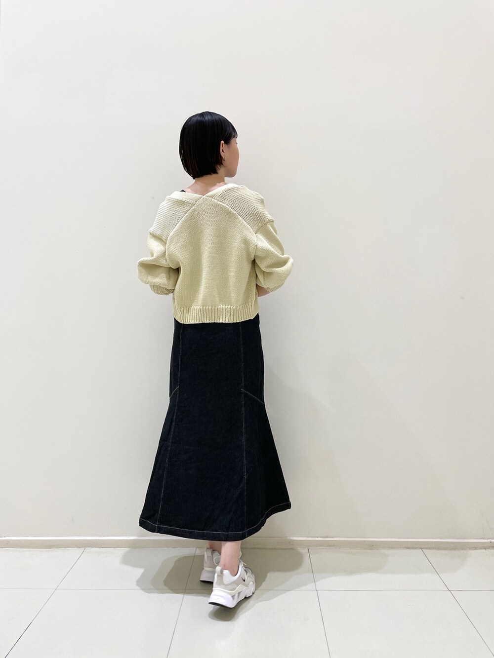 ブラック系のワンピース、ベージュ系のカーディガン/ボレロを着用したレディースの春コーディネートの4枚目の写真