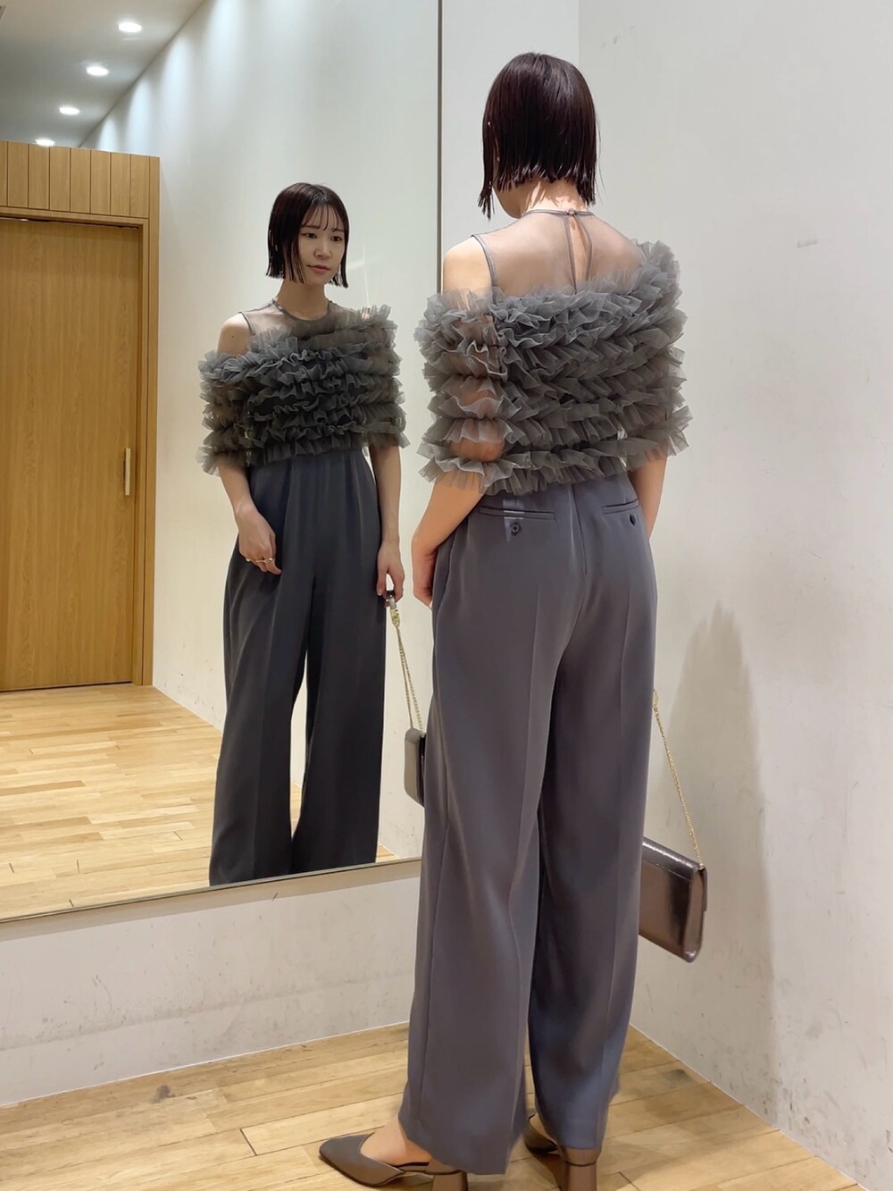 シルバー系のハンドバッグ、その他のパンプス、グレー系のパンツドレスを着用したレディースの冬コーディネートの3枚目の写真