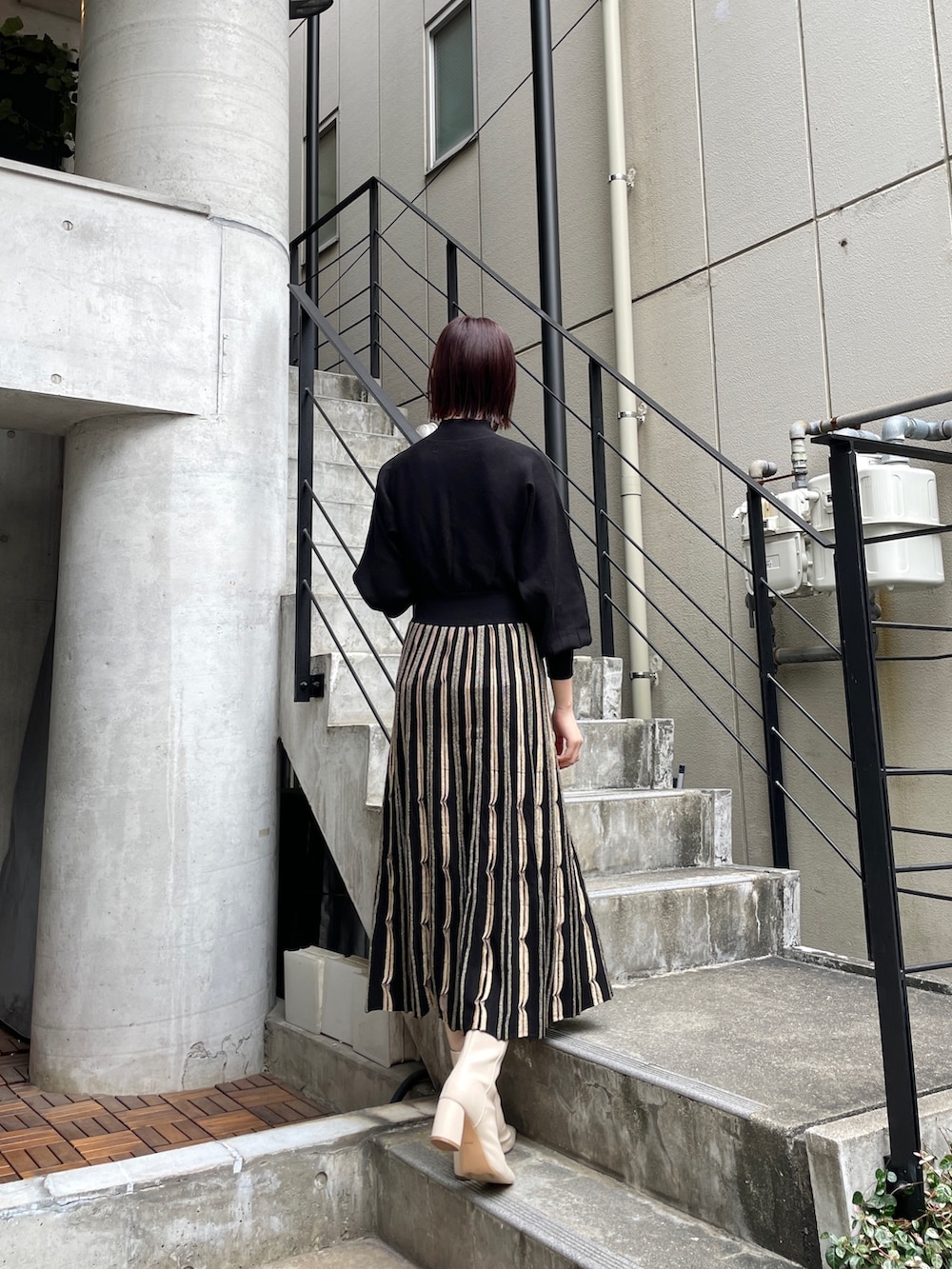 ホワイト系のブーツ、ブラック系のワンピース、グレー系のノーカラーコートを着用したレディースの冬コーディネートの4枚目の写真