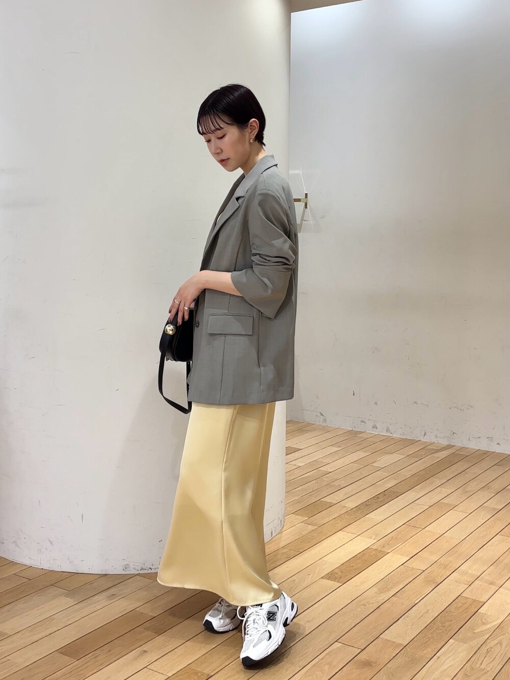 ホワイト系のワンピース、ホワイト系のテーラードジャケット、ブラック系のショルダーバッグを着用したレディースの春コーディネートの2枚目の写真