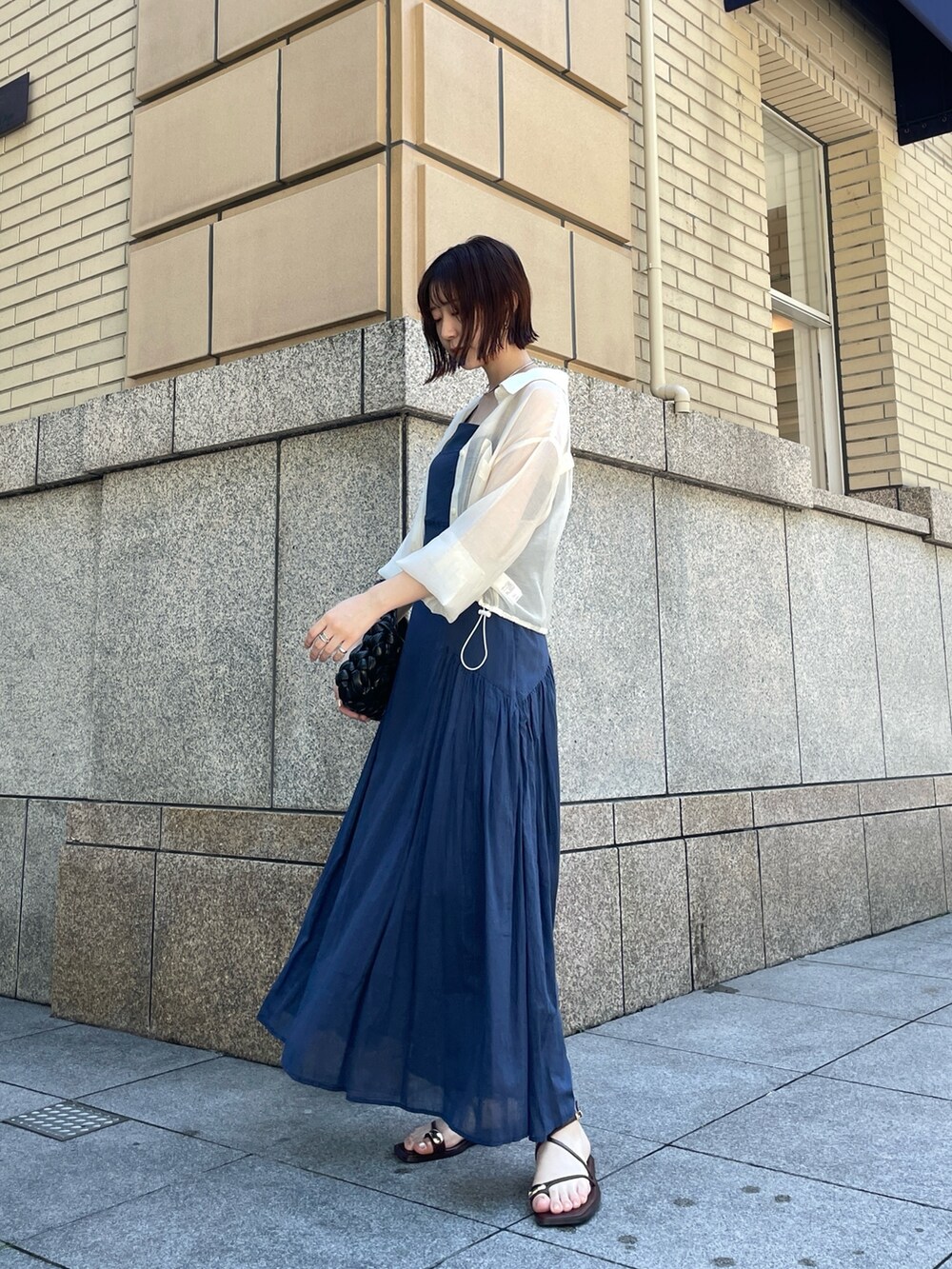 ブラウン系のサンダル、ブルー系のワンピース、ホワイト系のシャツ/ブラウスを着用したレディースの夏コーディネートの4枚目の写真
