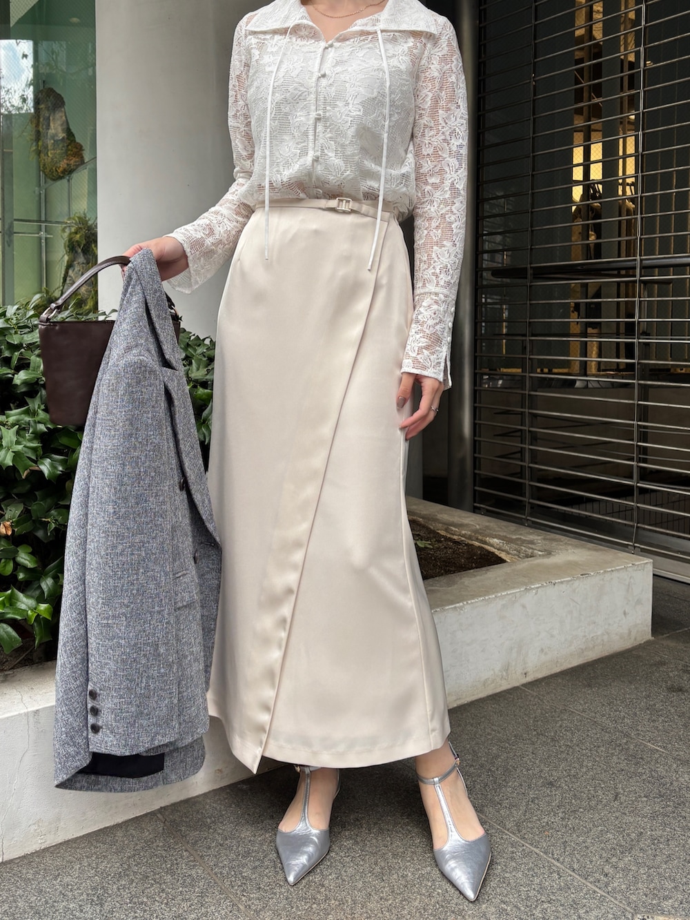 ホワイト系のスカート、ブラック系のテーラードジャケット、シルバー系のパンプスを着用したレディースの冬コーディネートの4枚目の写真