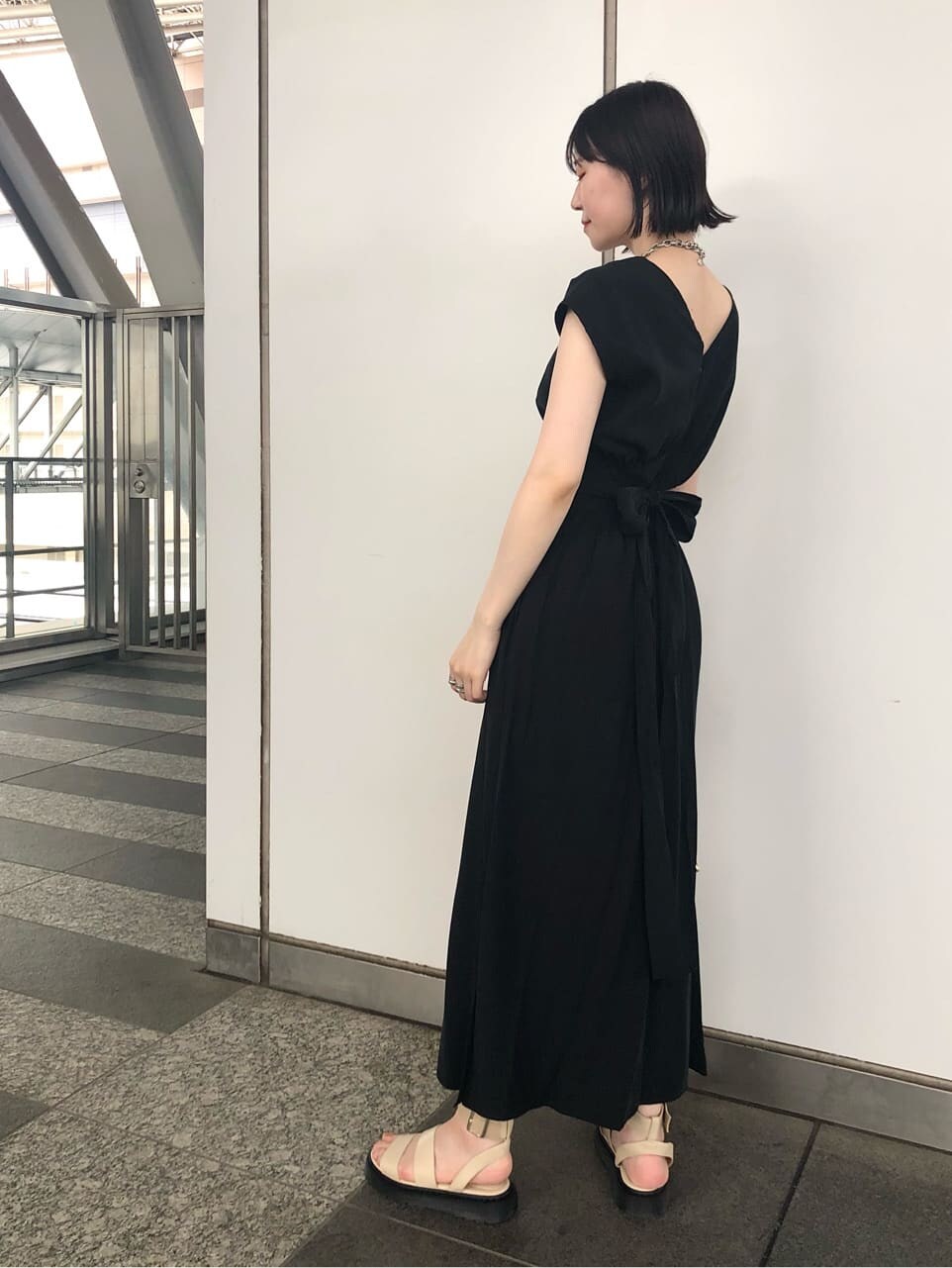 ホワイト系のショルダーバッグ、ブラック系のワンピース、ホワイト系のサンダルを着用したレディースの夏コーディネートの7枚目の写真