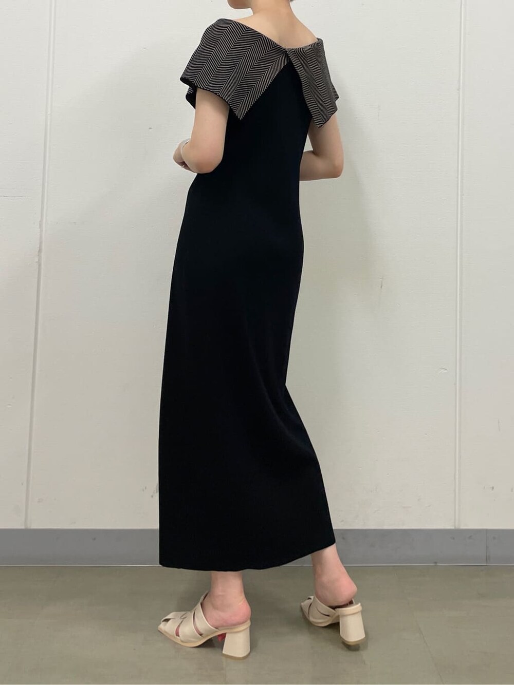 ホワイト系のサンダル、ブラック系のワンピース、シルバー系のバングル/リストバンドを着用したレディースの夏コーディネートの5枚目の写真