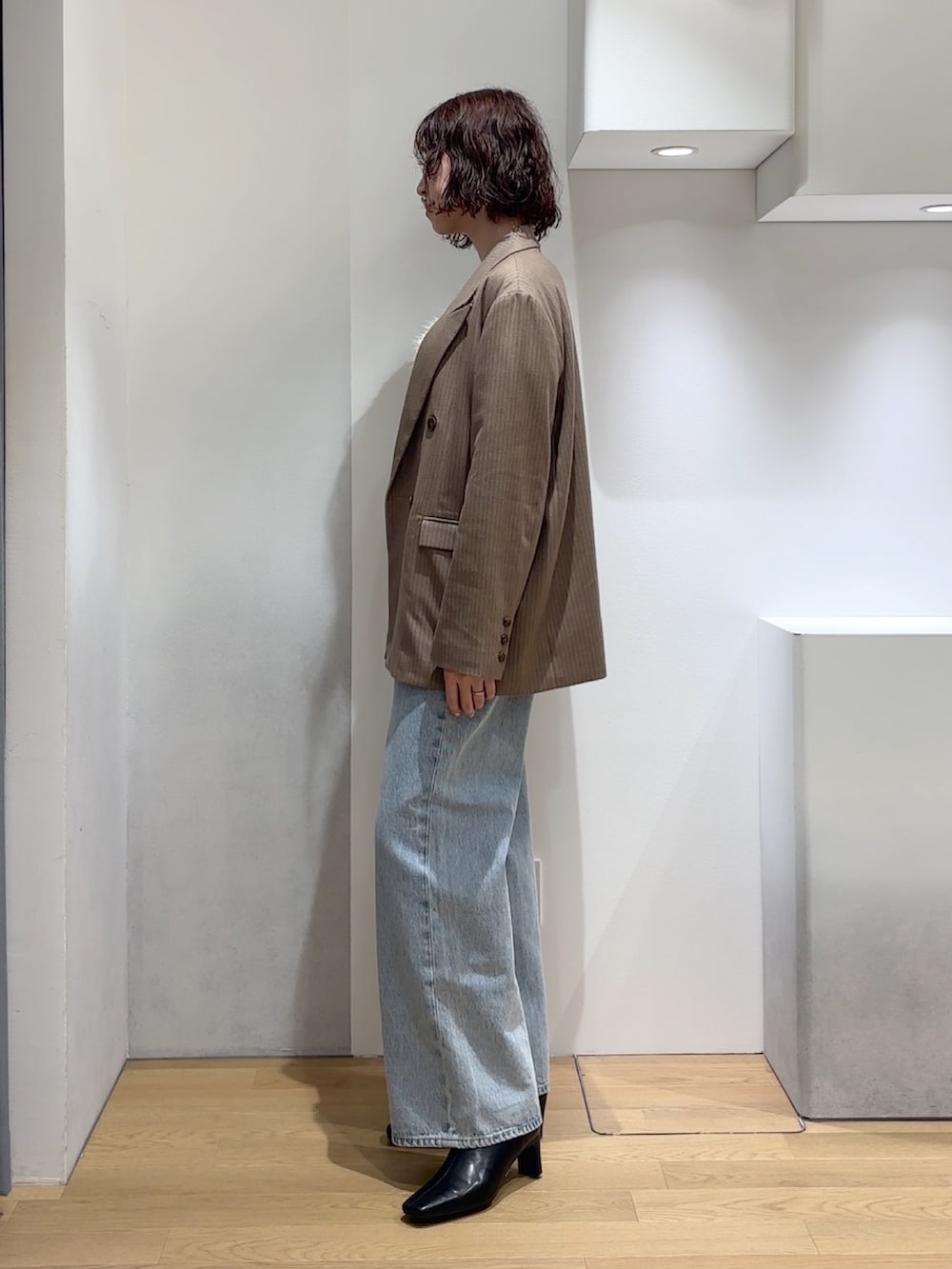 ホワイト系のニット/セーター、ブルー系のデニムパンツ、ブラック系のブーツを着用したレディースの秋コーディネートの5枚目の写真