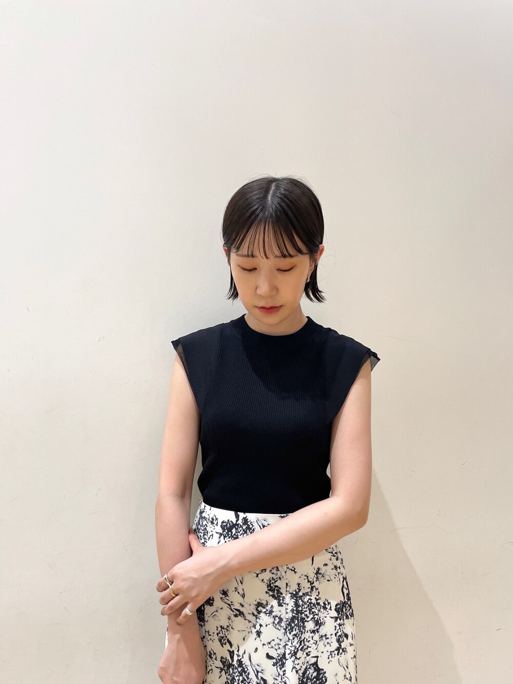 ブラック系のニット/セーター、ブルー系のスカート、ブラック系のハンドバッグを着用したレディースの夏コーディネートの5枚目の写真