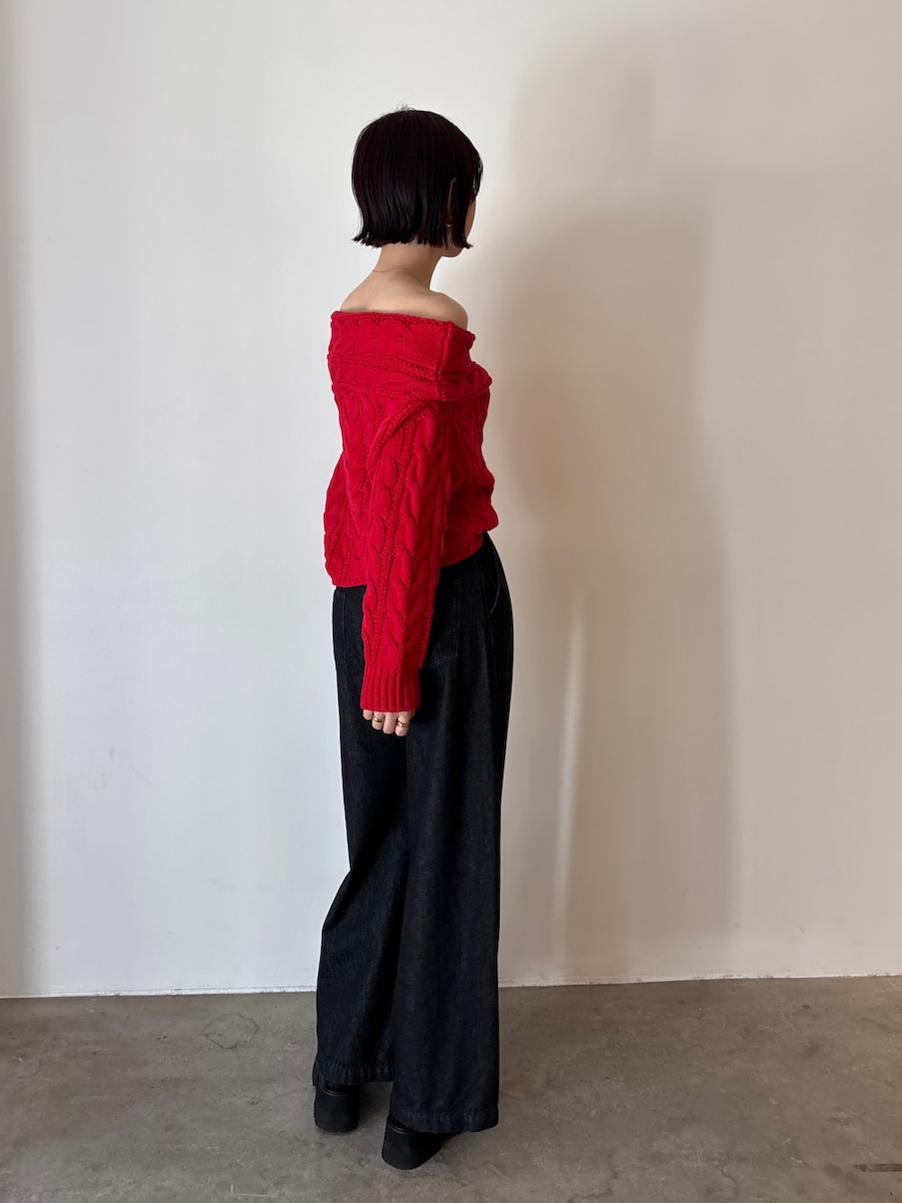 ブラック系のデニムパンツ、レッド系のニット/セーター、ブラック系のローファーを着用したレディースの秋コーディネートの4枚目の写真